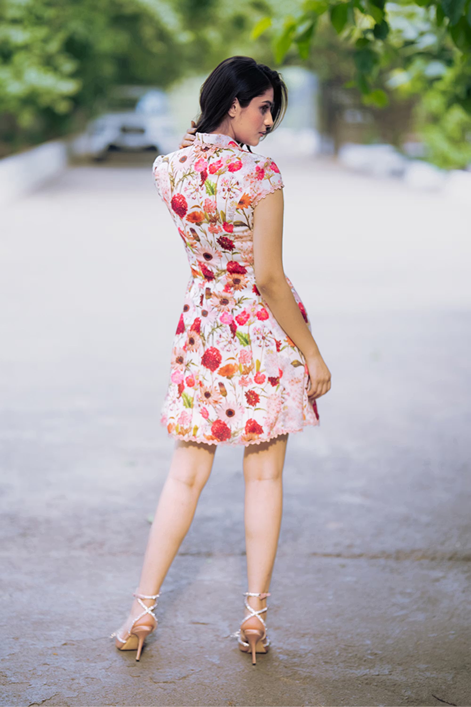 Back view of ivory floral collared shirt dress with sleeveless design and button detail