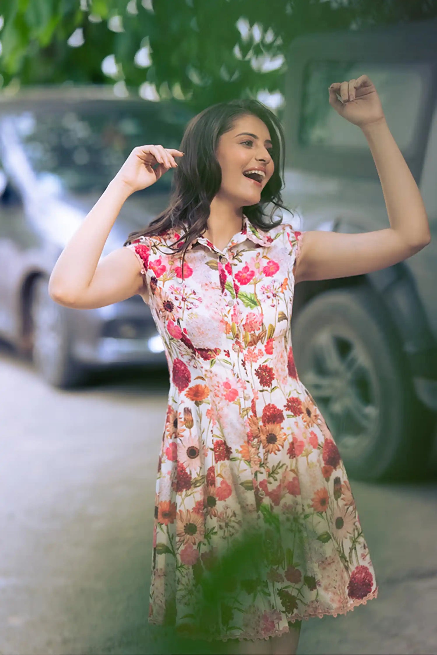 Woman smiling in ivory floral collared shirt dress with red floral prints