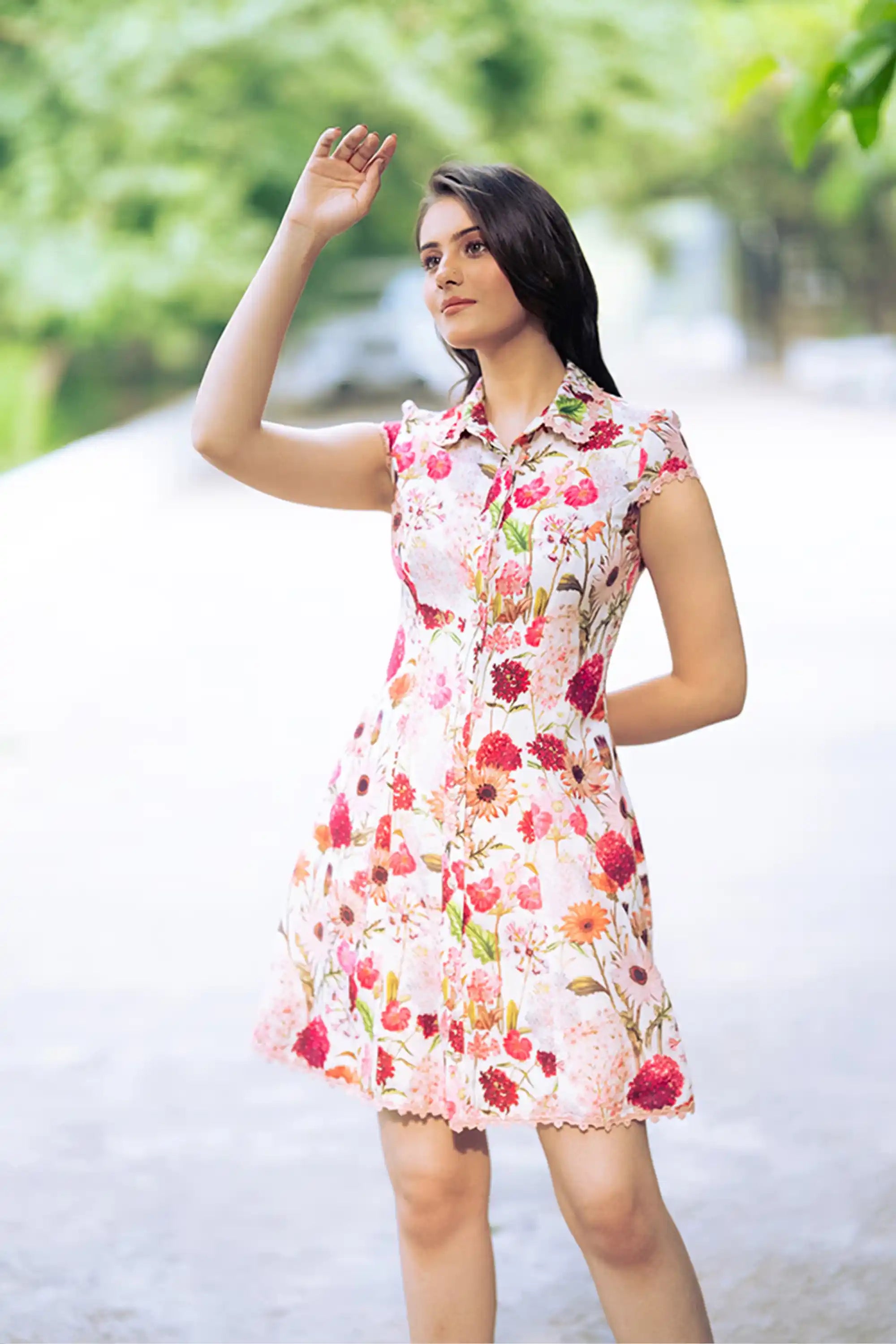 Woman in ivory floral collared shirt dress posing outdoors in sunlight