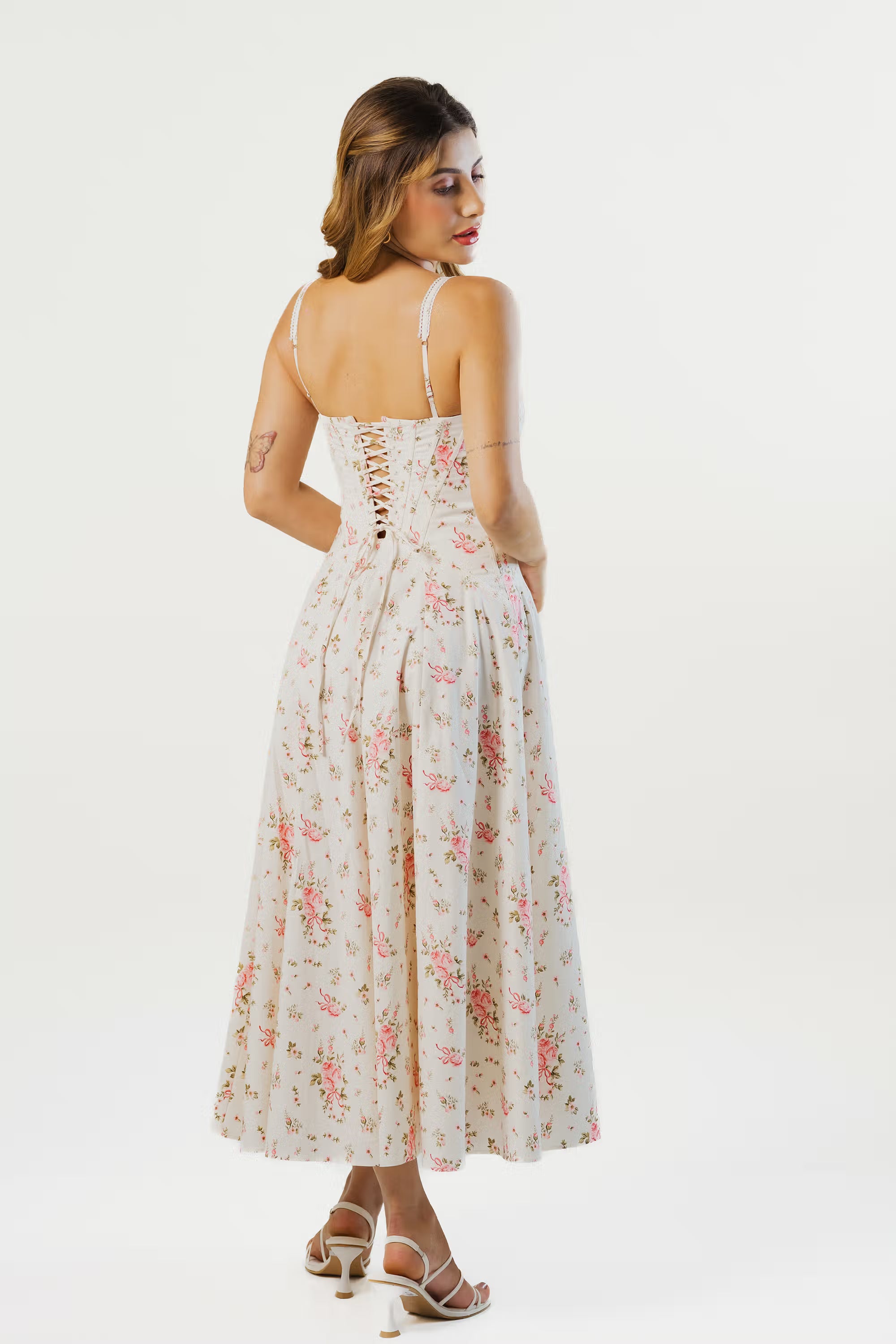 Back view of ivory floral corset midi dress featuring lace-up design and flared hem