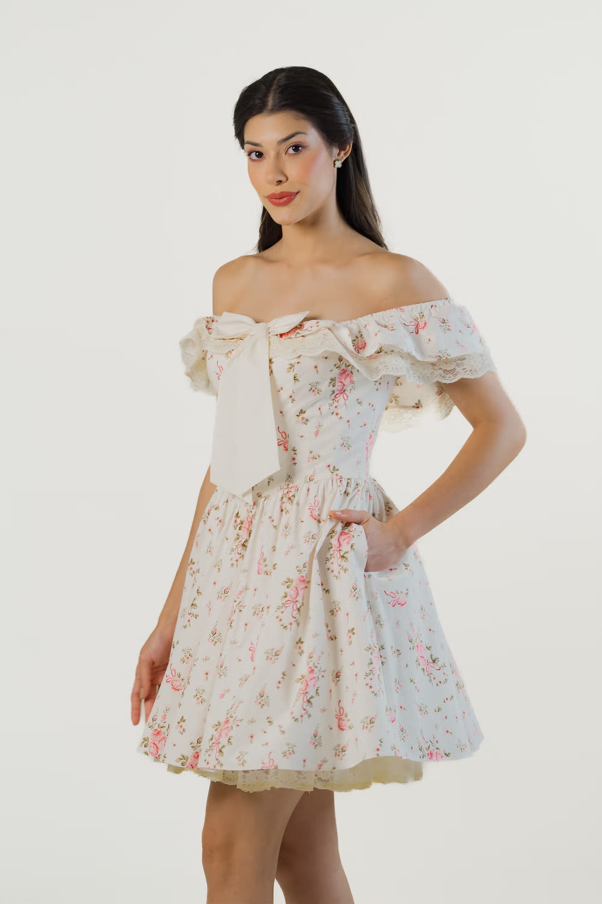 Elegant ivory off-shoulder floral dress with bow and lace ruffle trim, side angle.