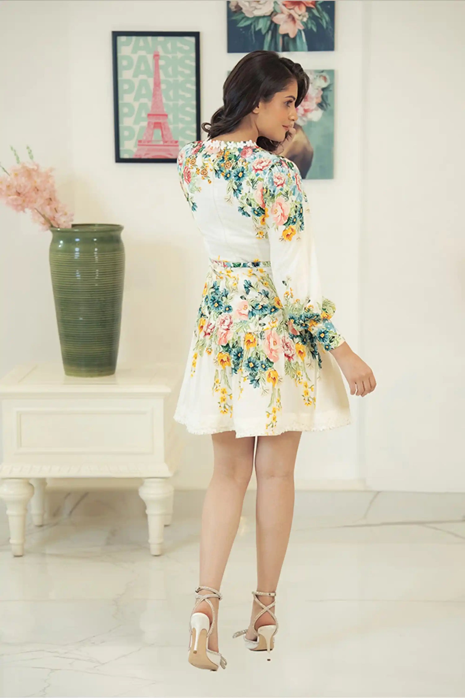 Back view of ivory floral mini dress with long sleeves and elegant fit