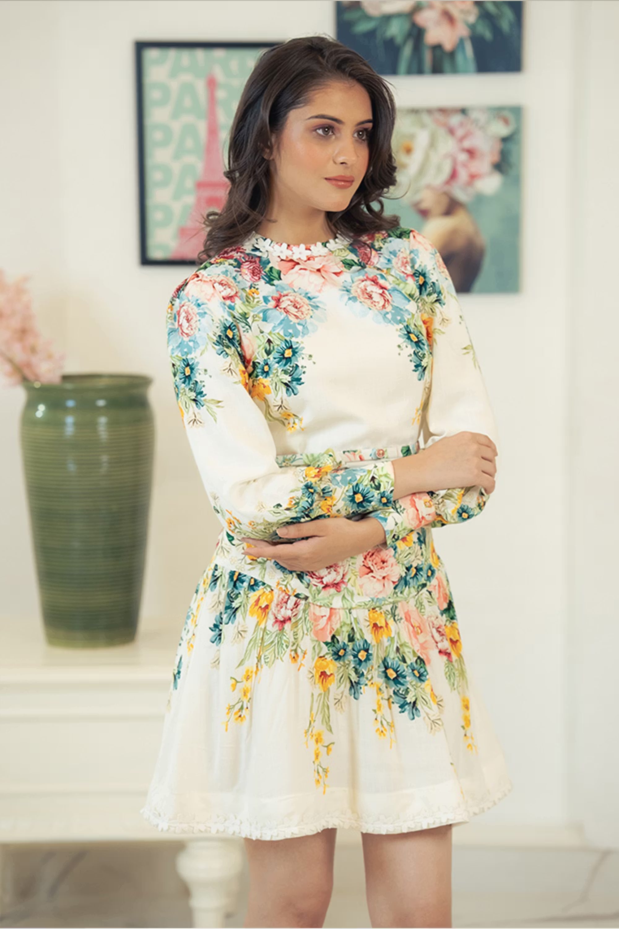Side profile of woman in ivory long sleeve mini dress with floral print.