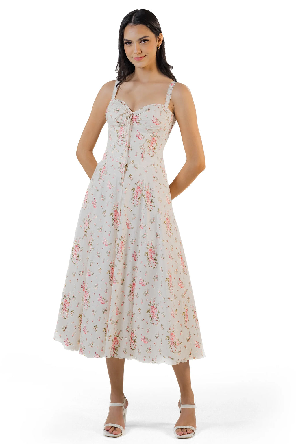 Woman holding skirt of ivory floral midi dress, flowy hemline with vintage-inspired floral print.