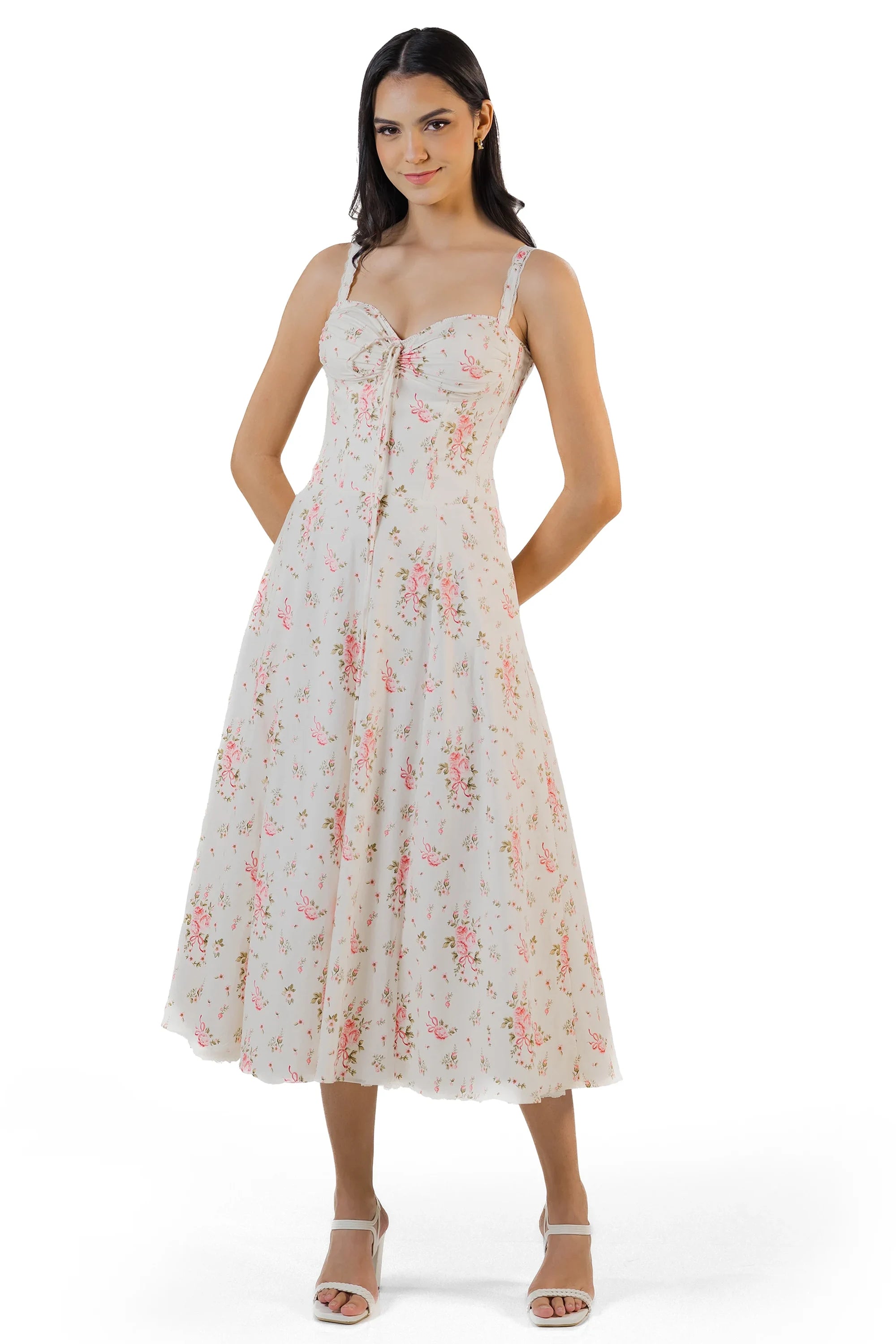 Woman holding skirt of ivory floral midi dress, flowy hemline with vintage-inspired floral print.