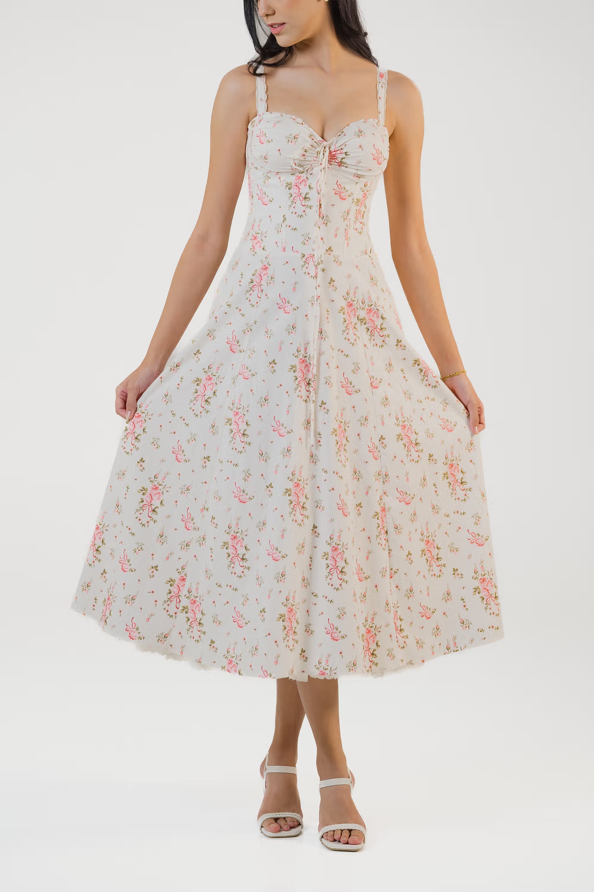 Ivory floral midi dress showing flowy skirt design with scattered rose patterns.