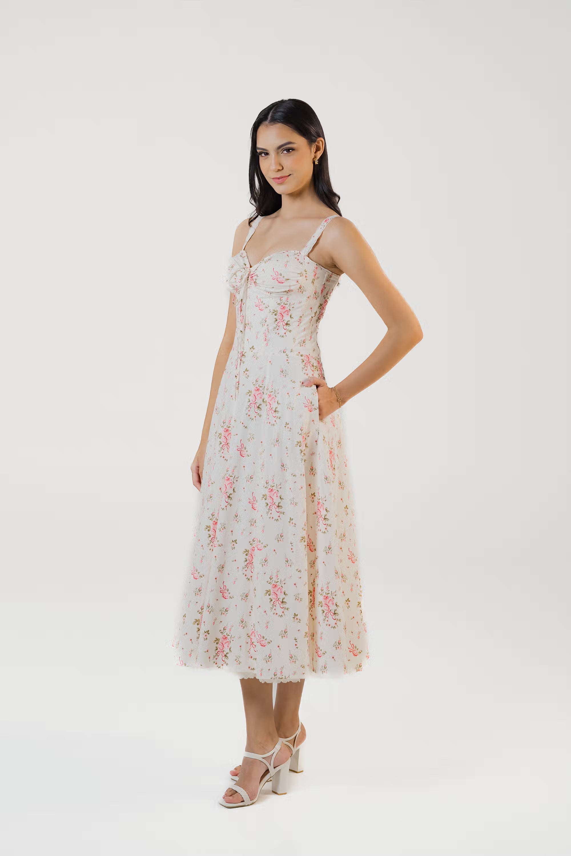 Side angle of ivory floral midi dress with practical hidden pockets.