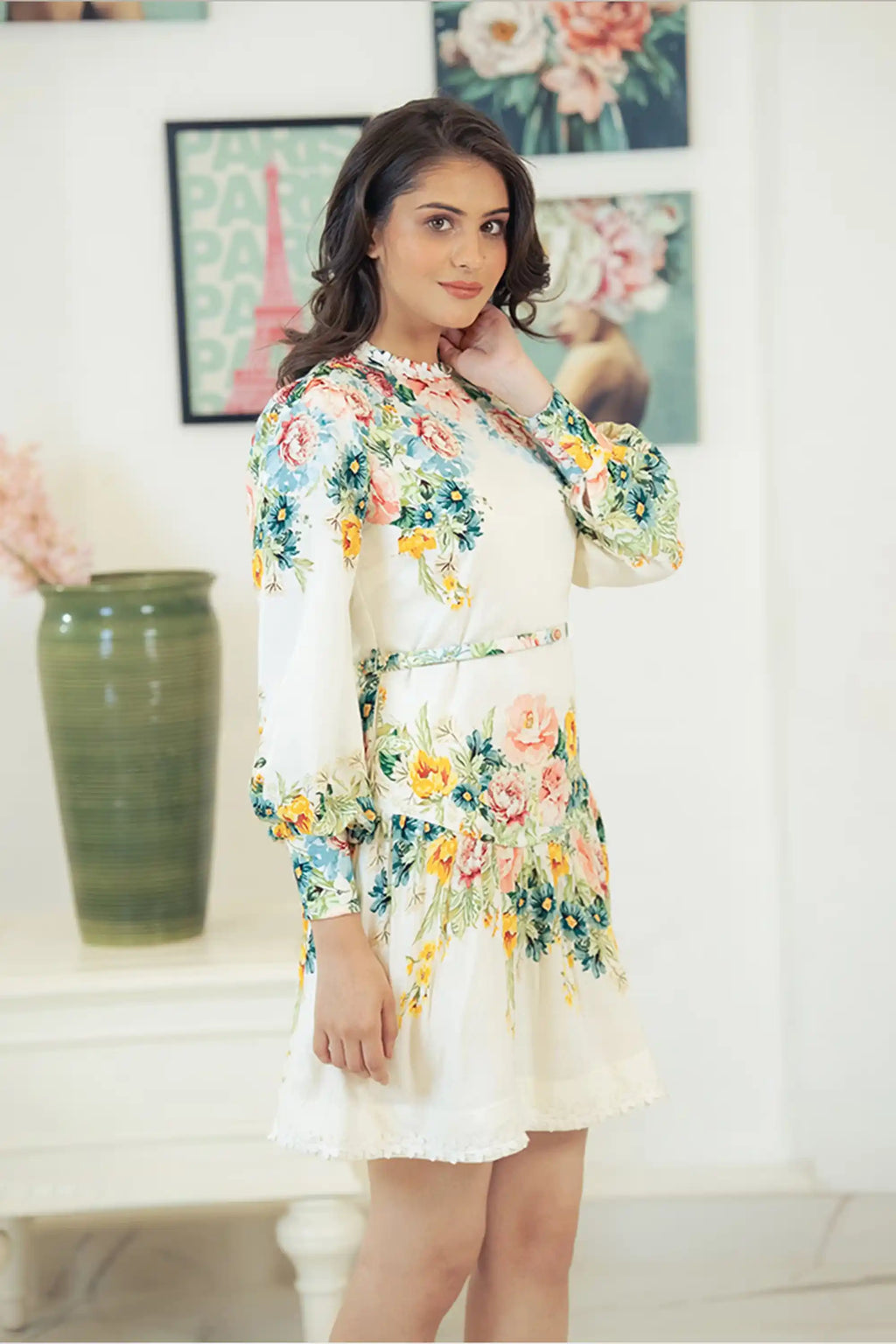 Side pose of ivory floral long-sleeve mini dress with cinched waist