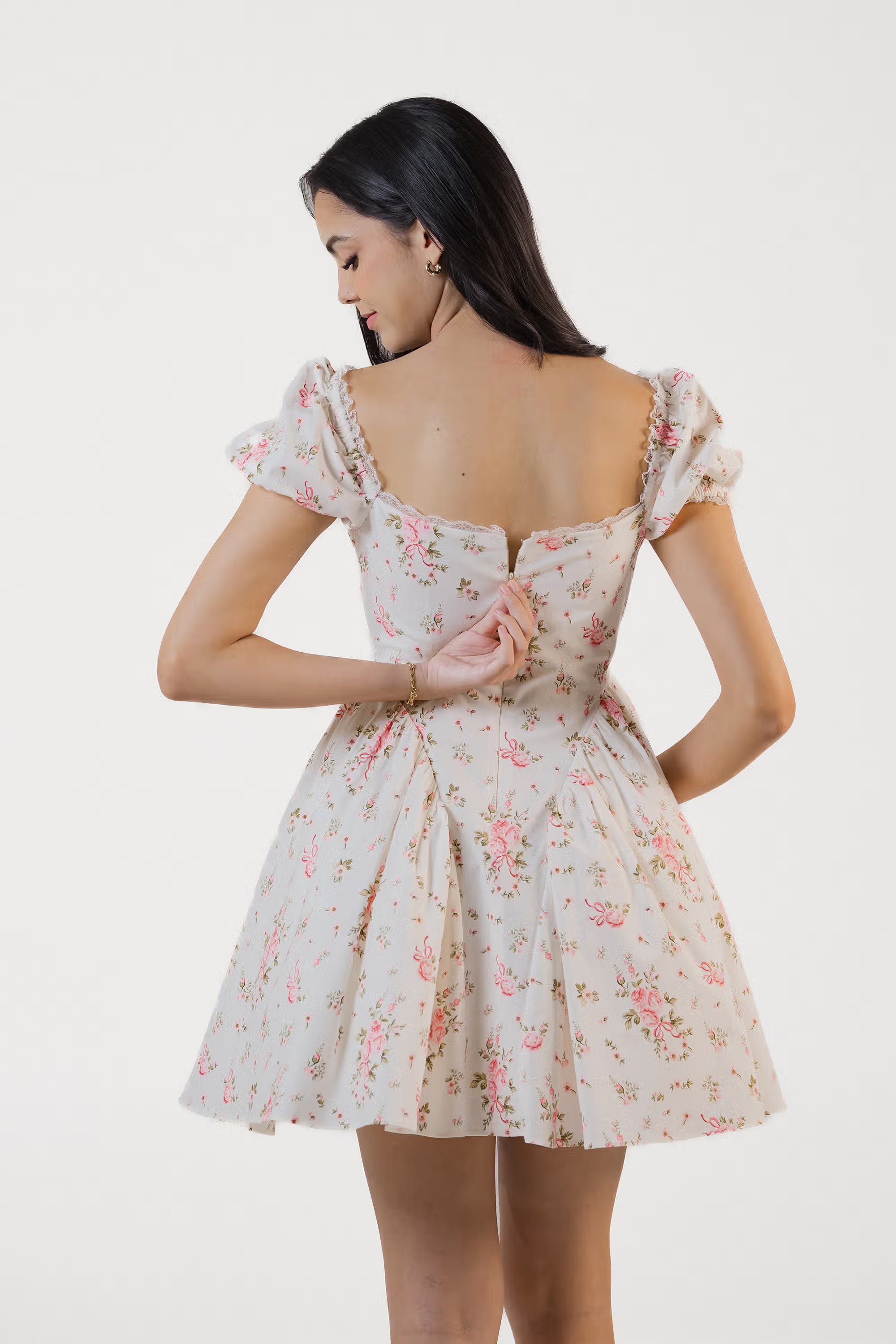 Back view of ivory floral puff sleeve mini dress with zipper closure and floral print