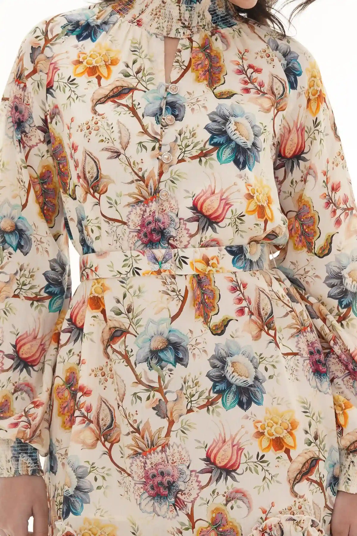 Close-up of Pretty Pixie ivory jacobean floral dress with smocked high neck and butterfly brooch belt