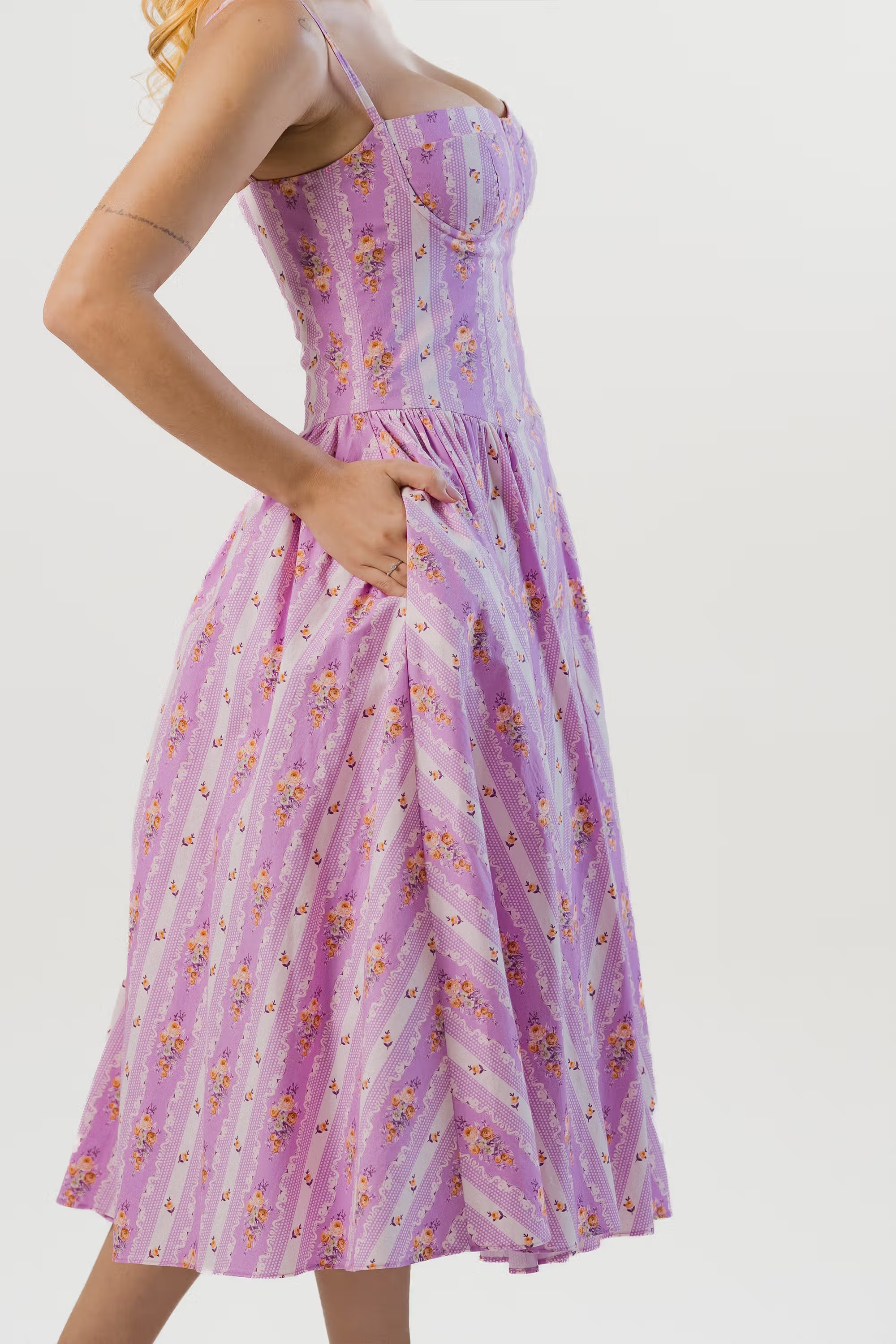 Side view of lavender floral striped corset midi dress with pockets