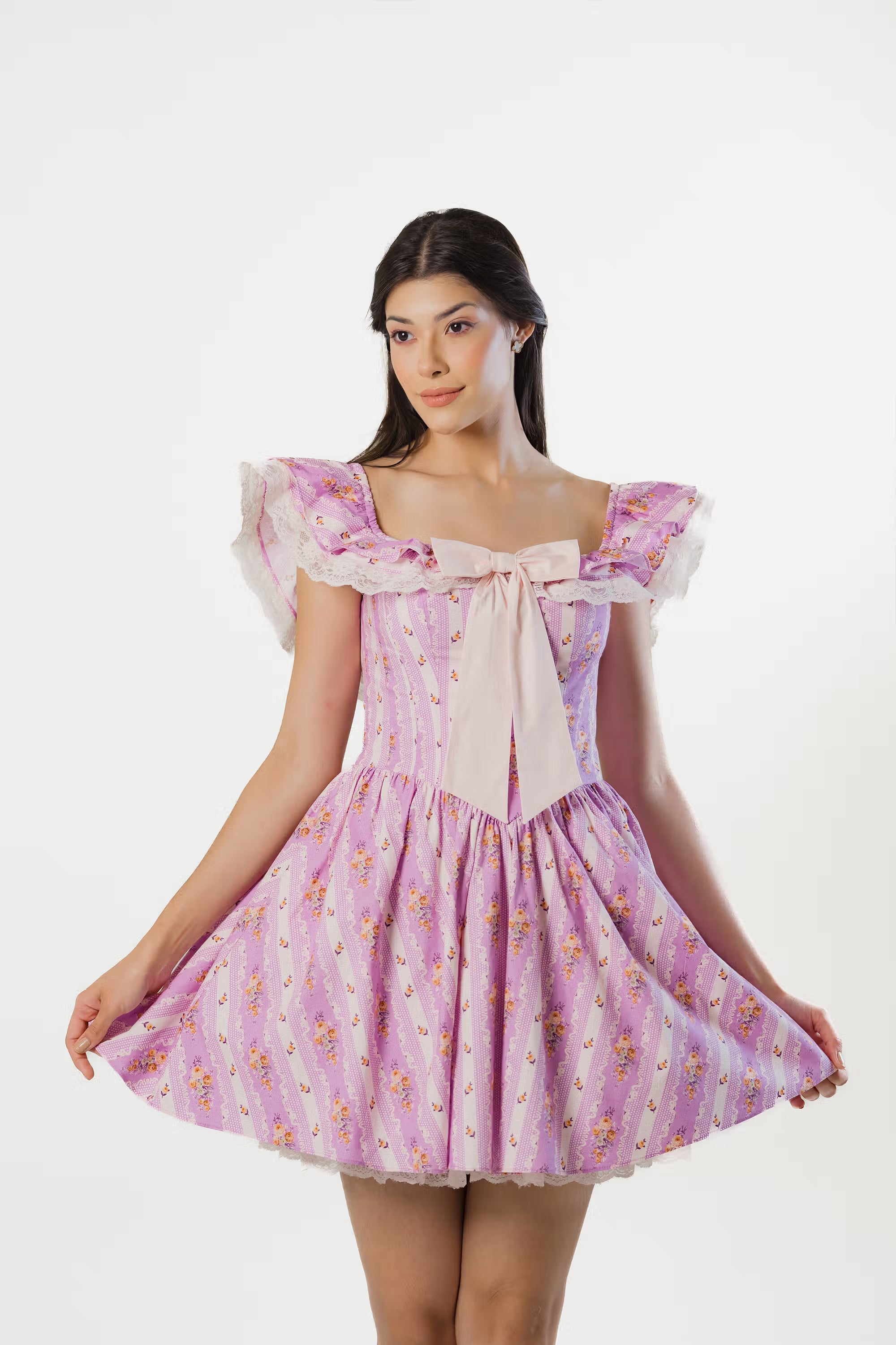 Woman in lavender floral off-shoulder mini dress holding skirt.