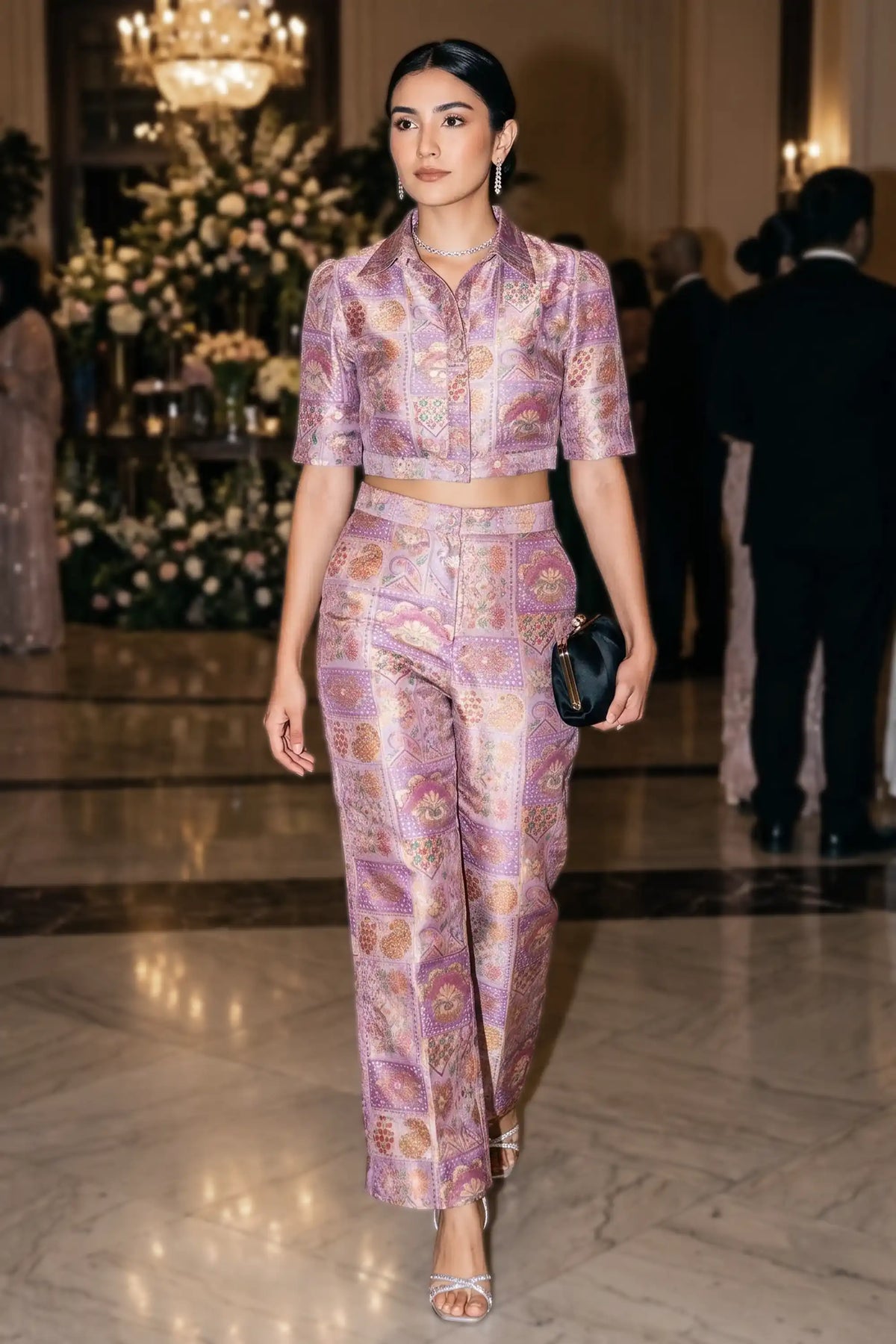 Woman walking through an elegant event hall wearing Pretty Pixie's lilac jacquard floral co-ord set