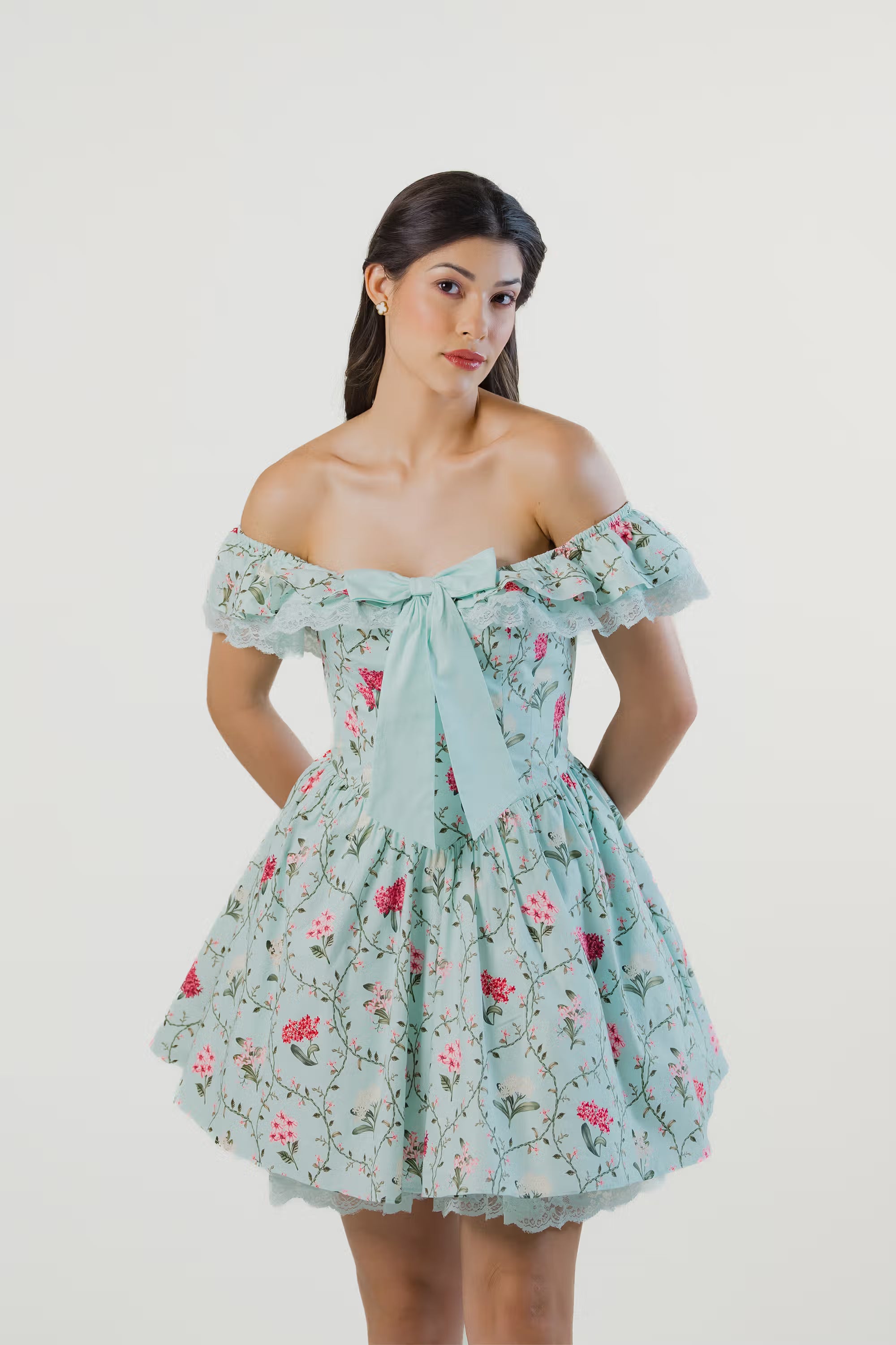 Close-up of mint green floral off-shoulder dress featuring statement bow tie and delicate lace neckline.