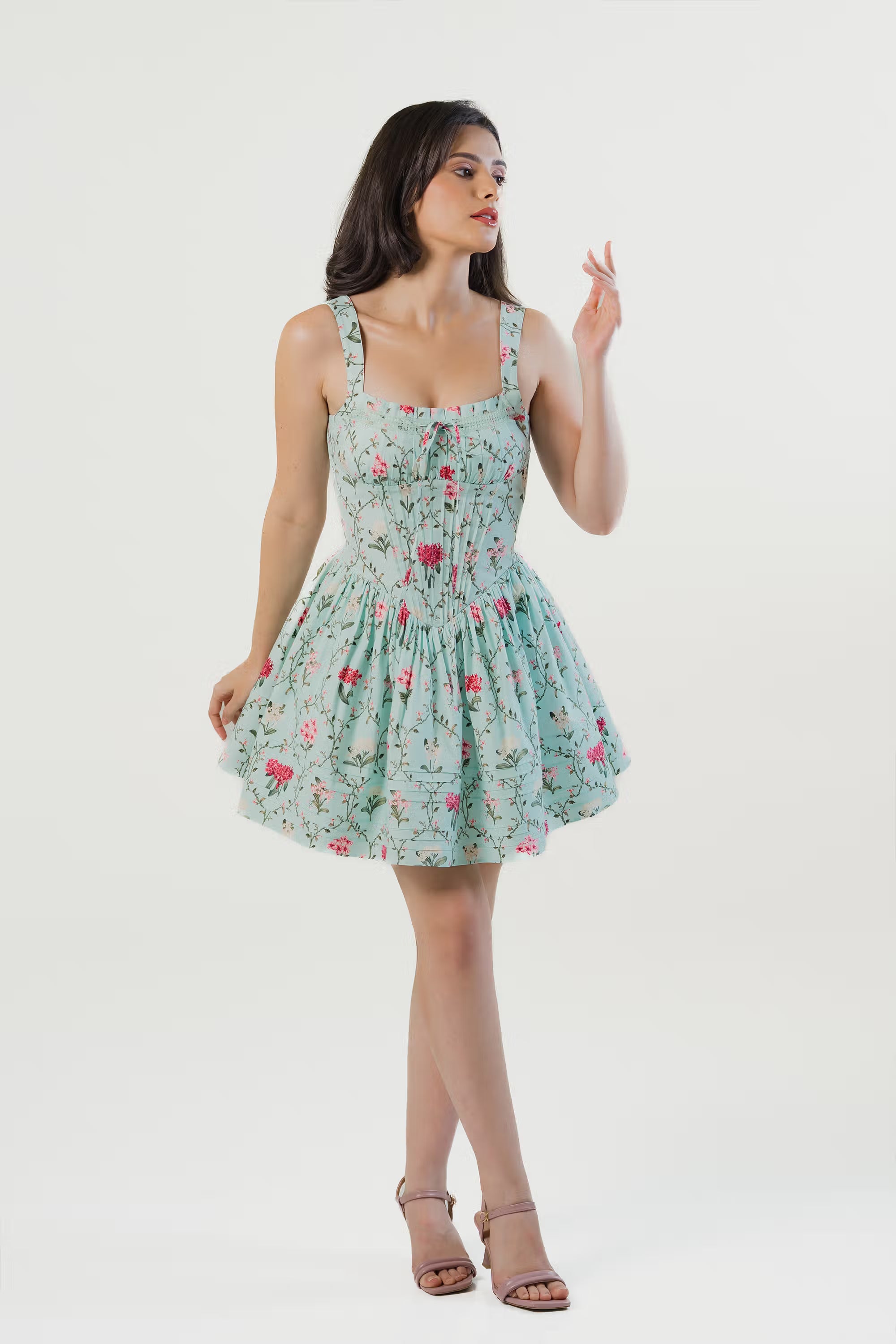 Model smiling in mint green floral mini dress with wide shoulder straps