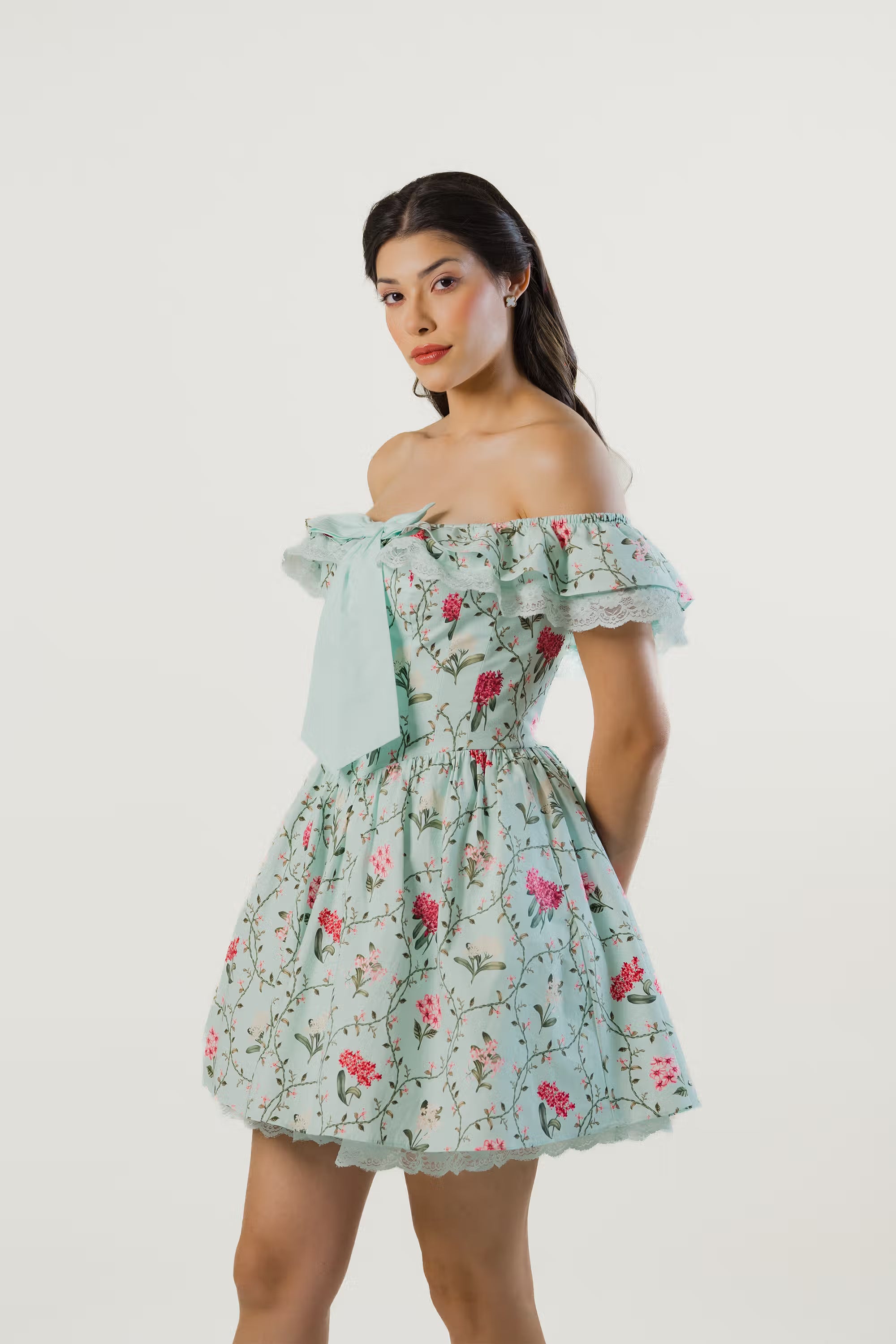 Side profile of mint green floral off-shoulder short dress with bow detail and flowy silhouette.