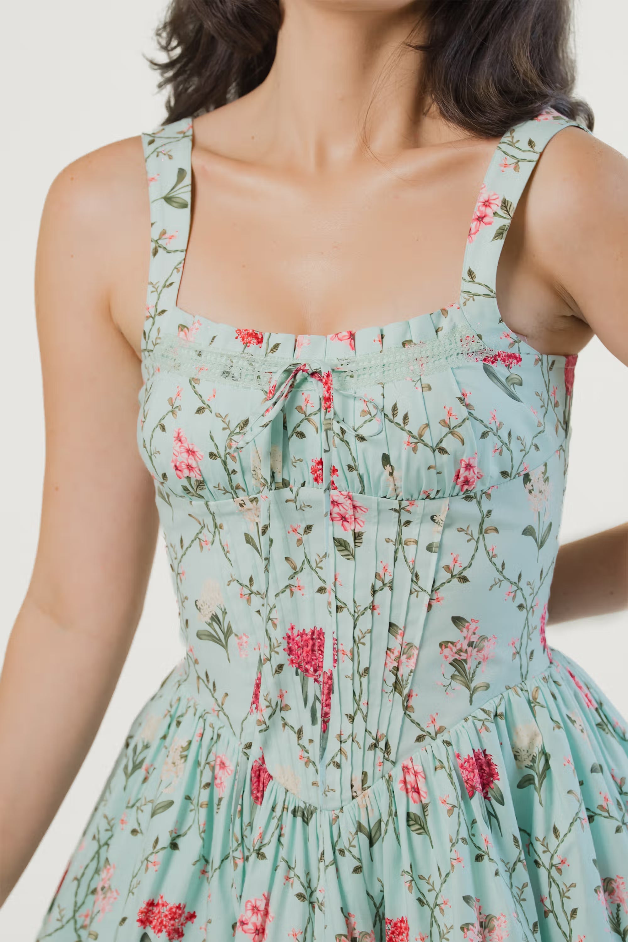 Closeup of bodice with pink and red floral print on mint green mini dress