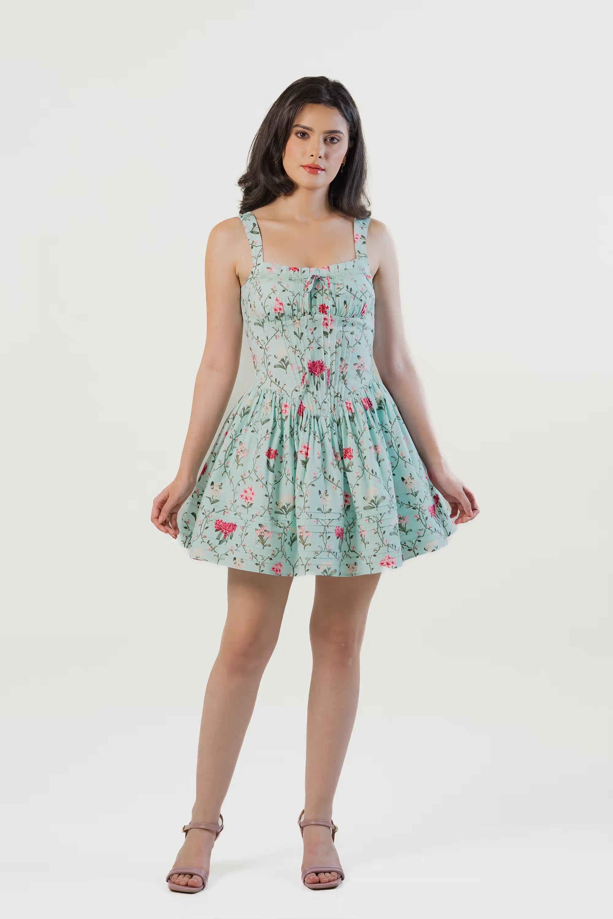 Front view of a mint green floral mini dress with square neckline and pleated skirt