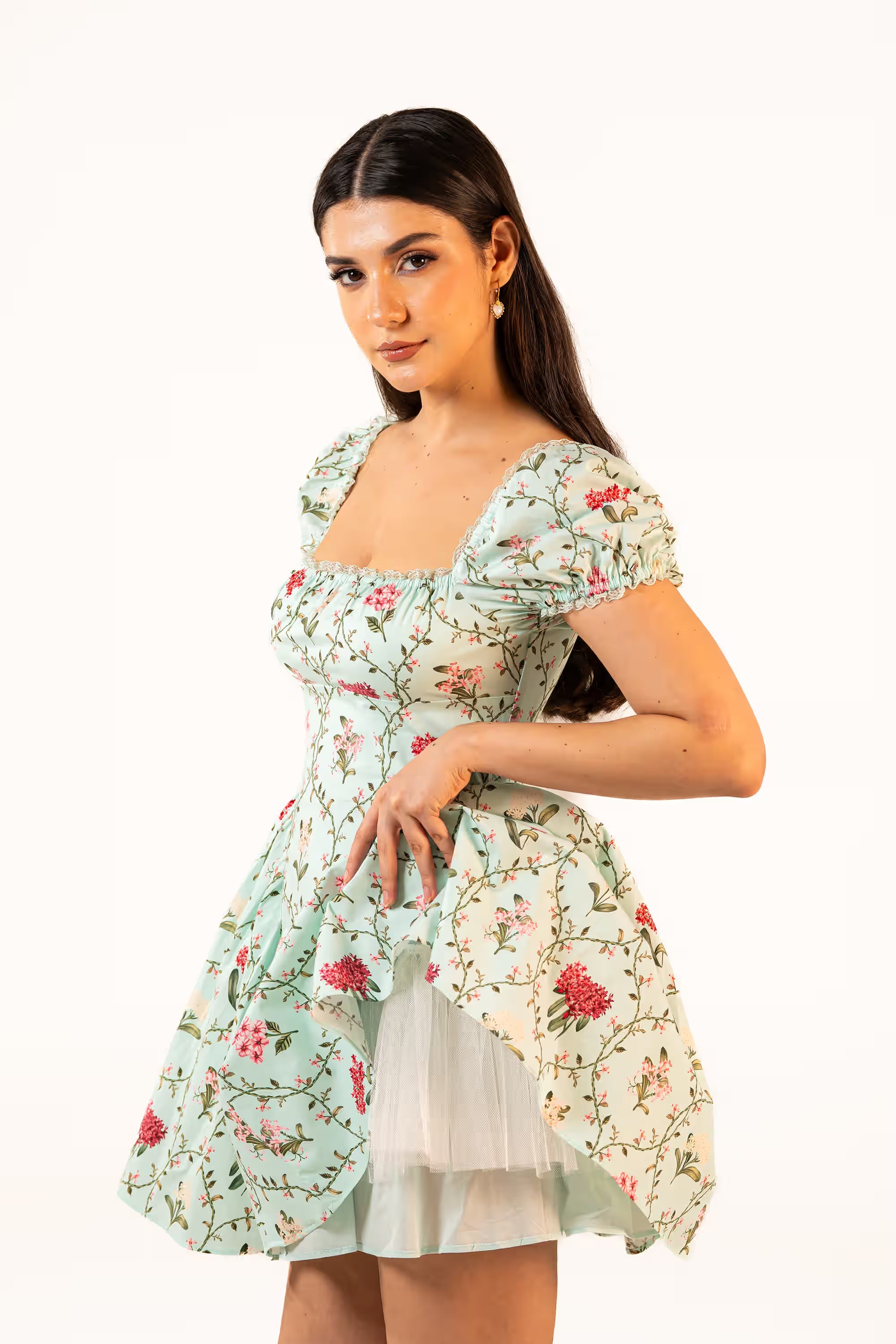 Side profile of mint green mini dress with red and pink floral print and puff sleeves