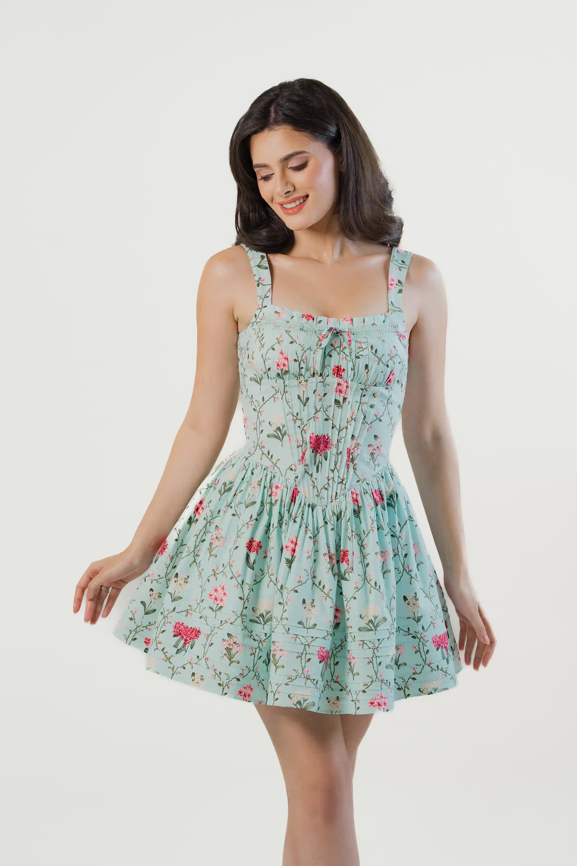 mint green floral mini dress showing fitted waistline and flare skirt