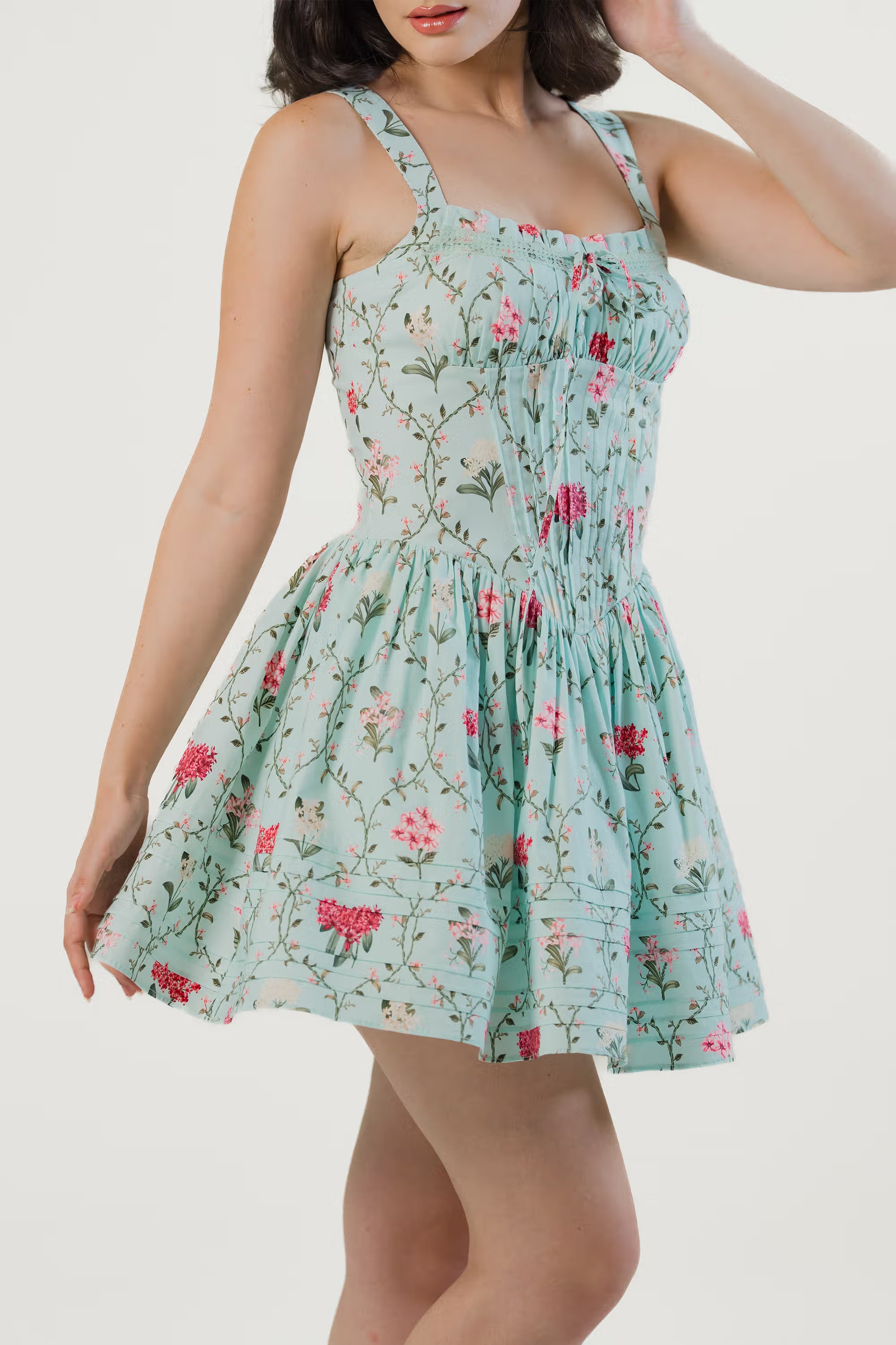 Twirl pose showcasing mint green floral dress flowy skirt and floral details