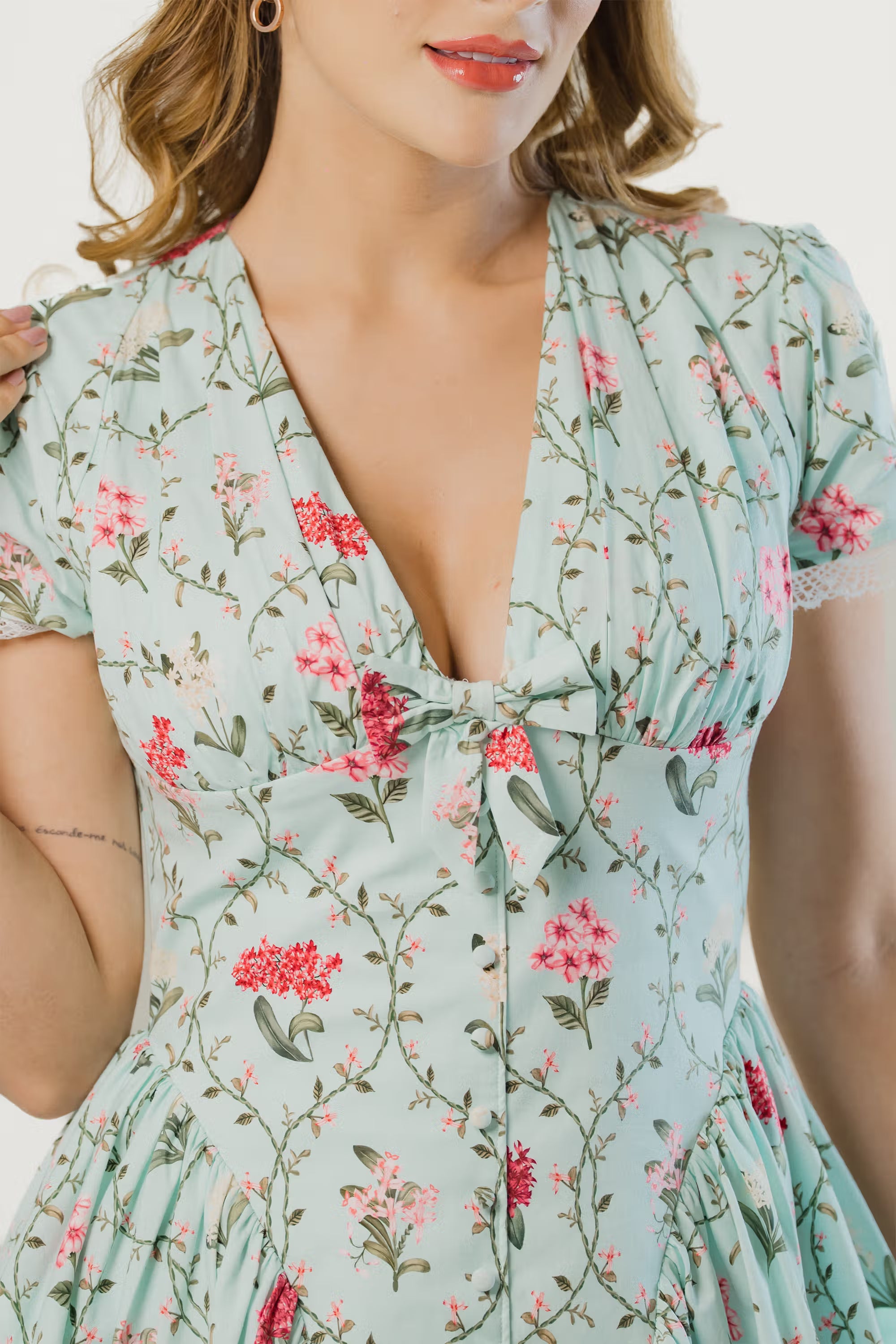 Close-up of mint green short floral dress with bow detail on neckline and lace trim sleeves for women
