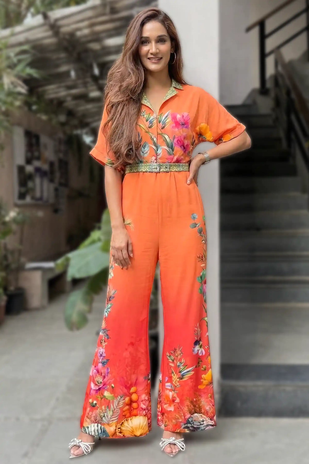 Mukti Mohan wearing Pretty Pixie coral orange floral collared belted wide-leg jumpsuit