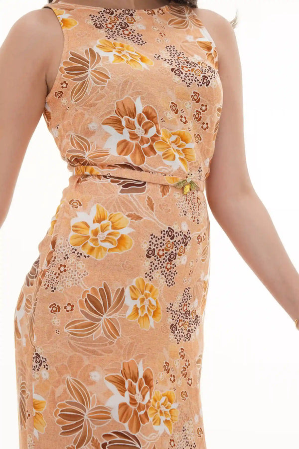 Close-up of Pretty Pixie mustard floral halter maxi dress with thin belt and crystal bee brooch detail