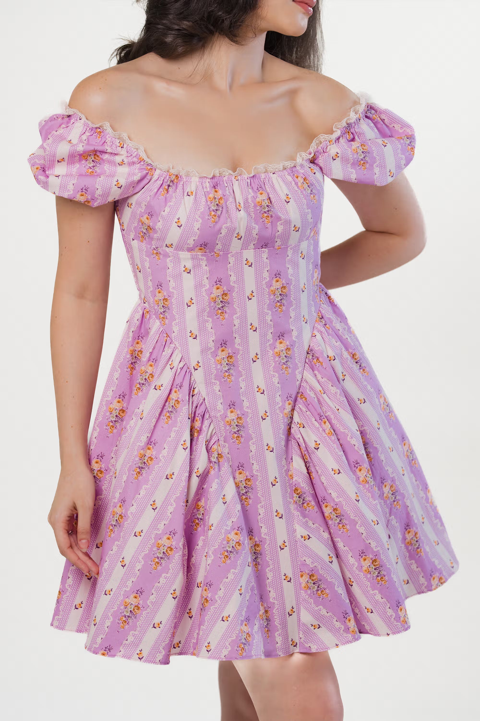 Feminine lavender floral mini dress styled off-shoulder with puff sleeves.