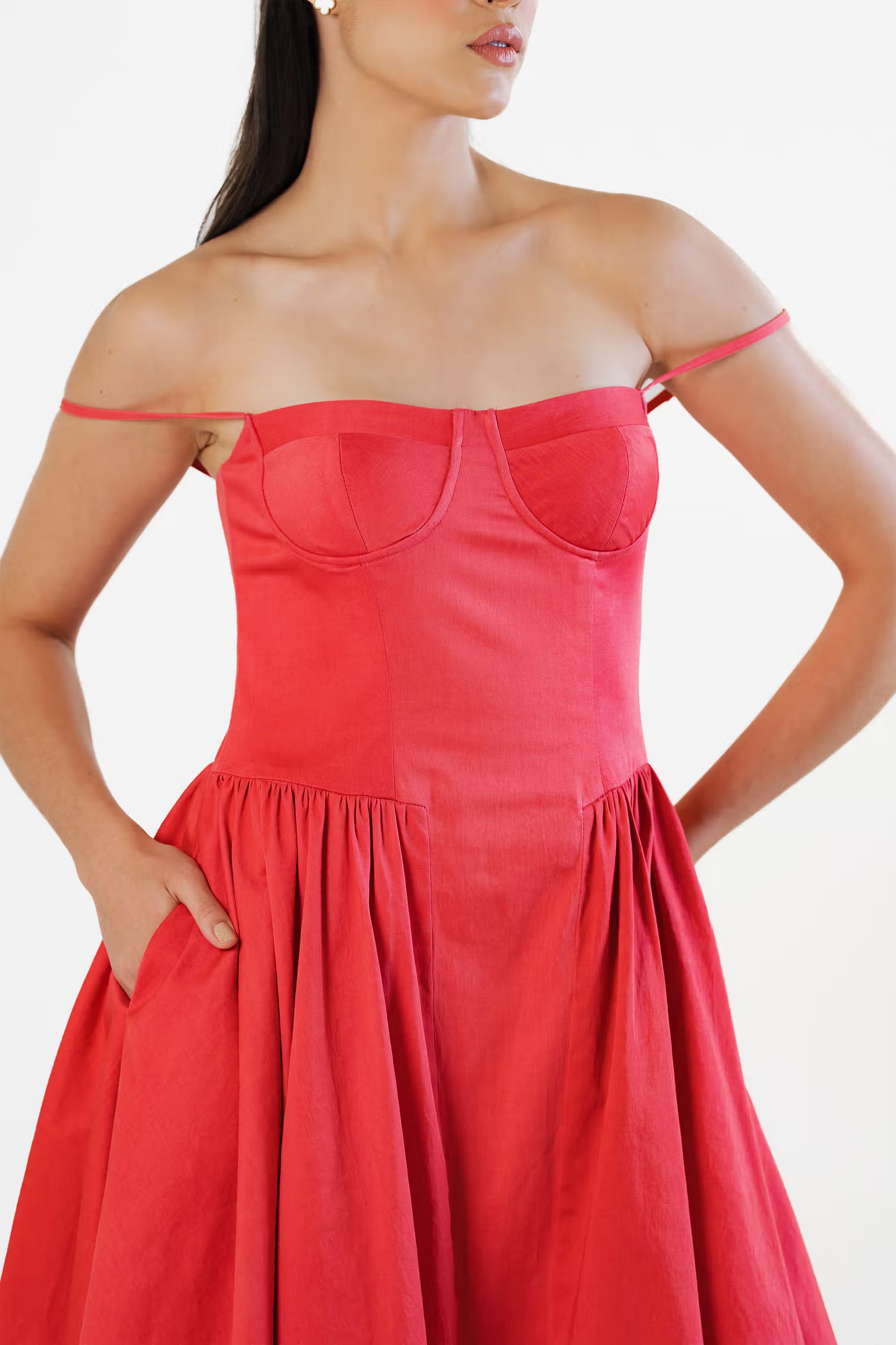Off-shoulder styling of red corset midi dress with dropped straps and fitted waist