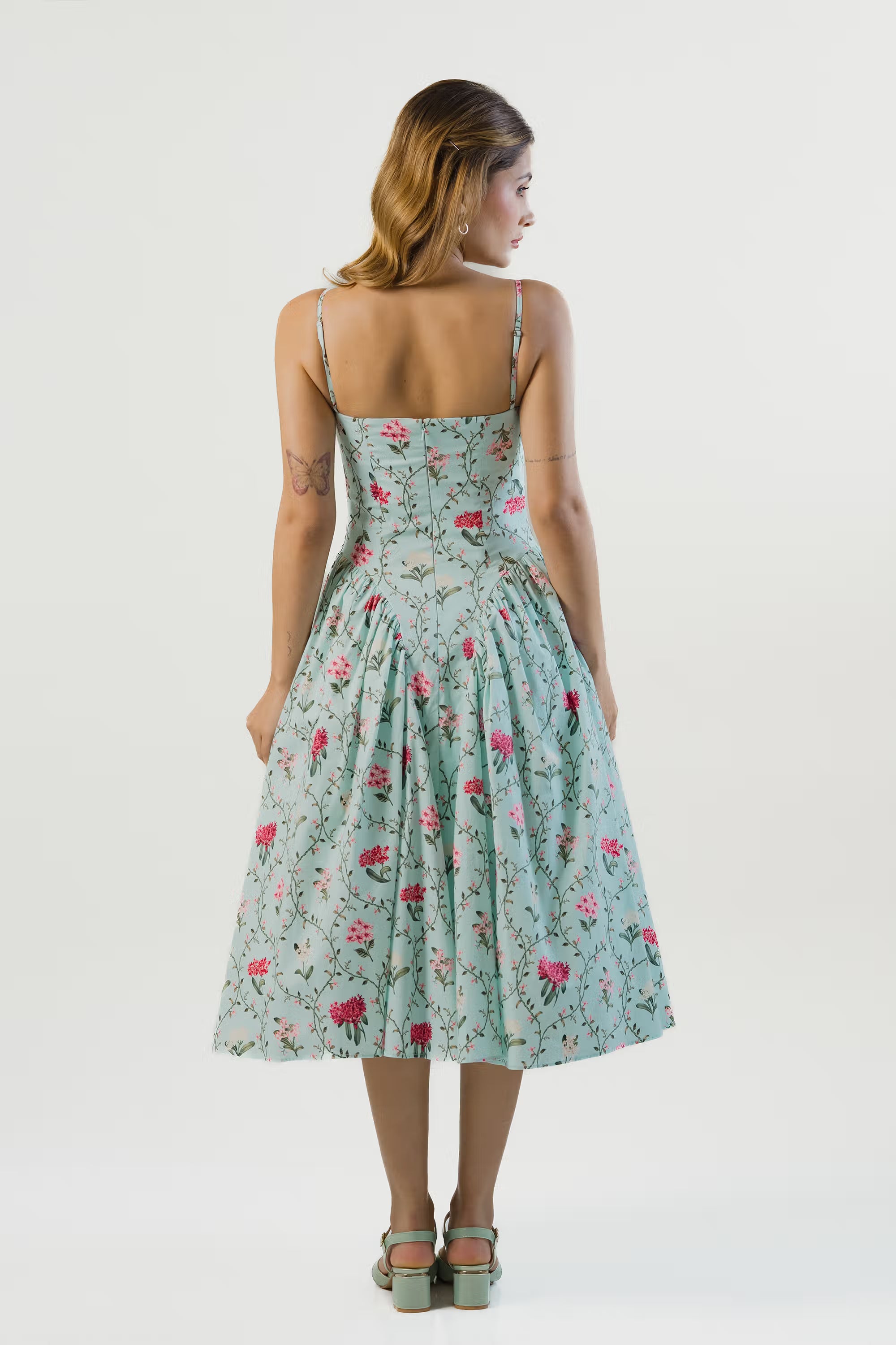 Pastel green floral dress, back view, fitted bodice and adjustable straps.