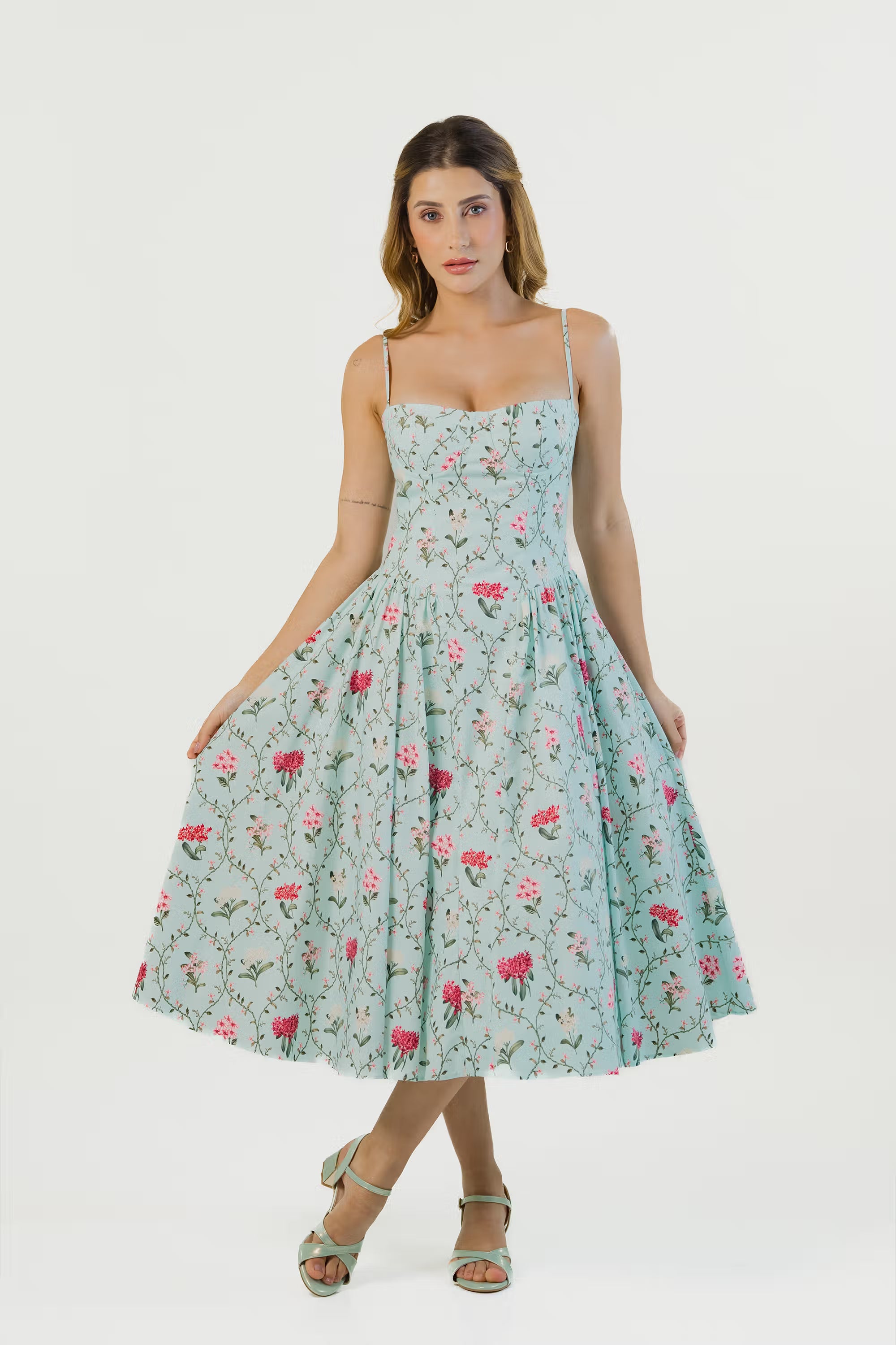 Pastel green floral midi dress, front view, flared skirt and pink flowers.