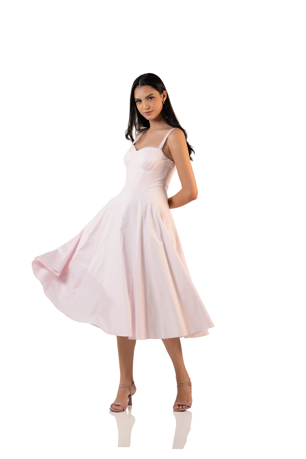Side angle showing twirl movement of pastel pink bustier midi dress with lace-trim straps and flowing skirt