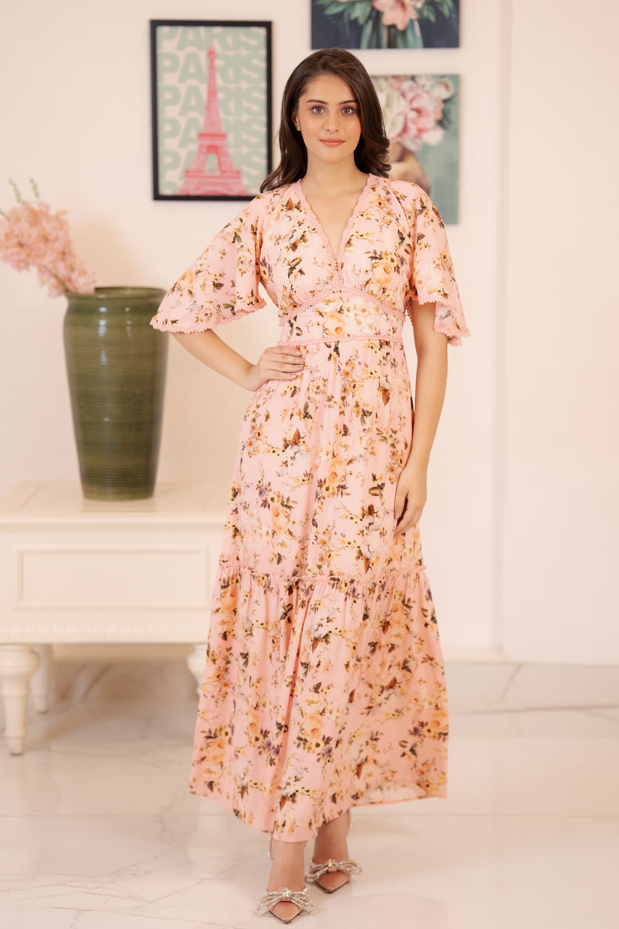 Front view of peach pink floral maxi dress with flared sleeves and flowy hem