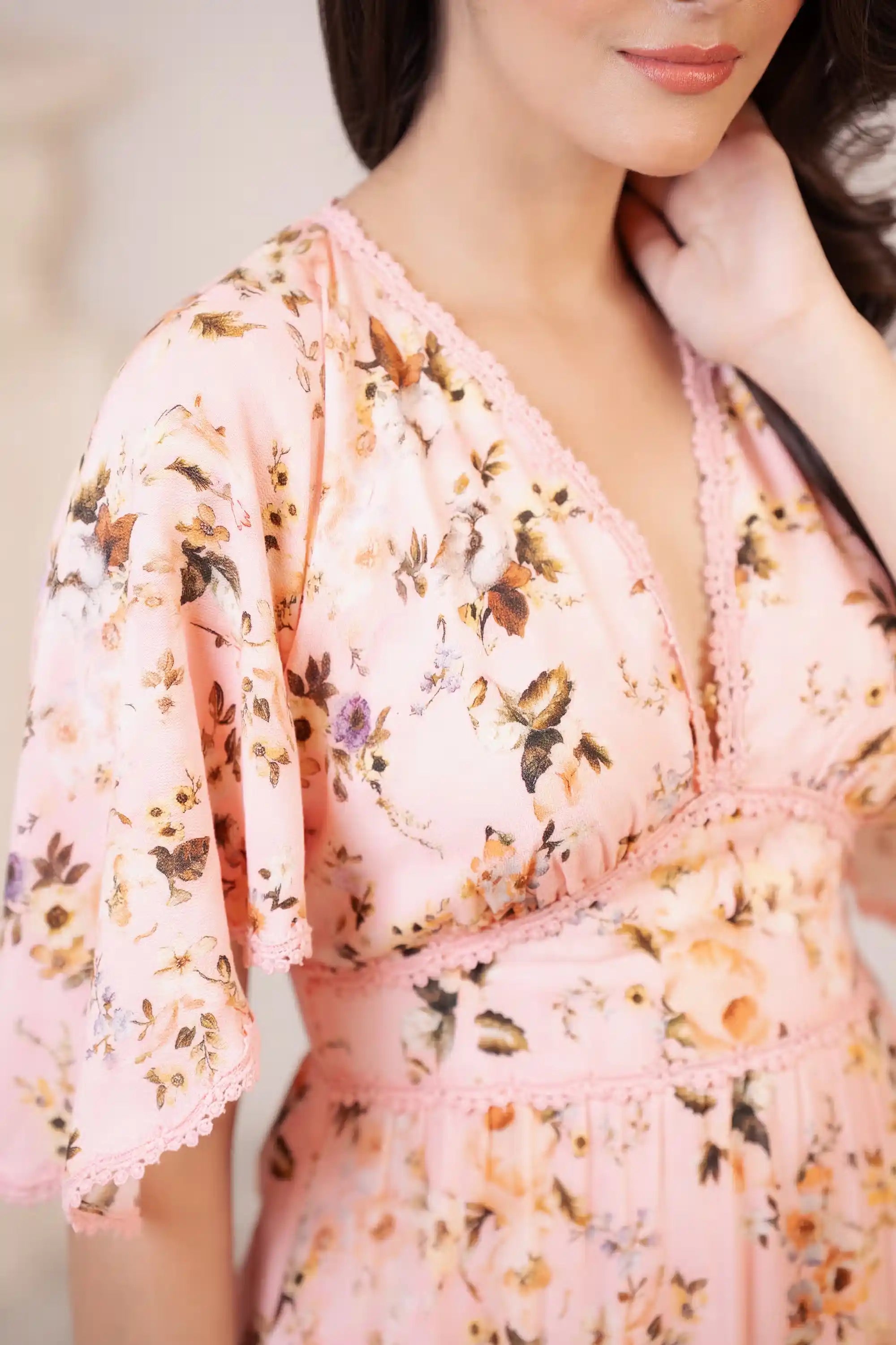 Peach pink maxi dress with floral print and lace V-neck detail closeup
