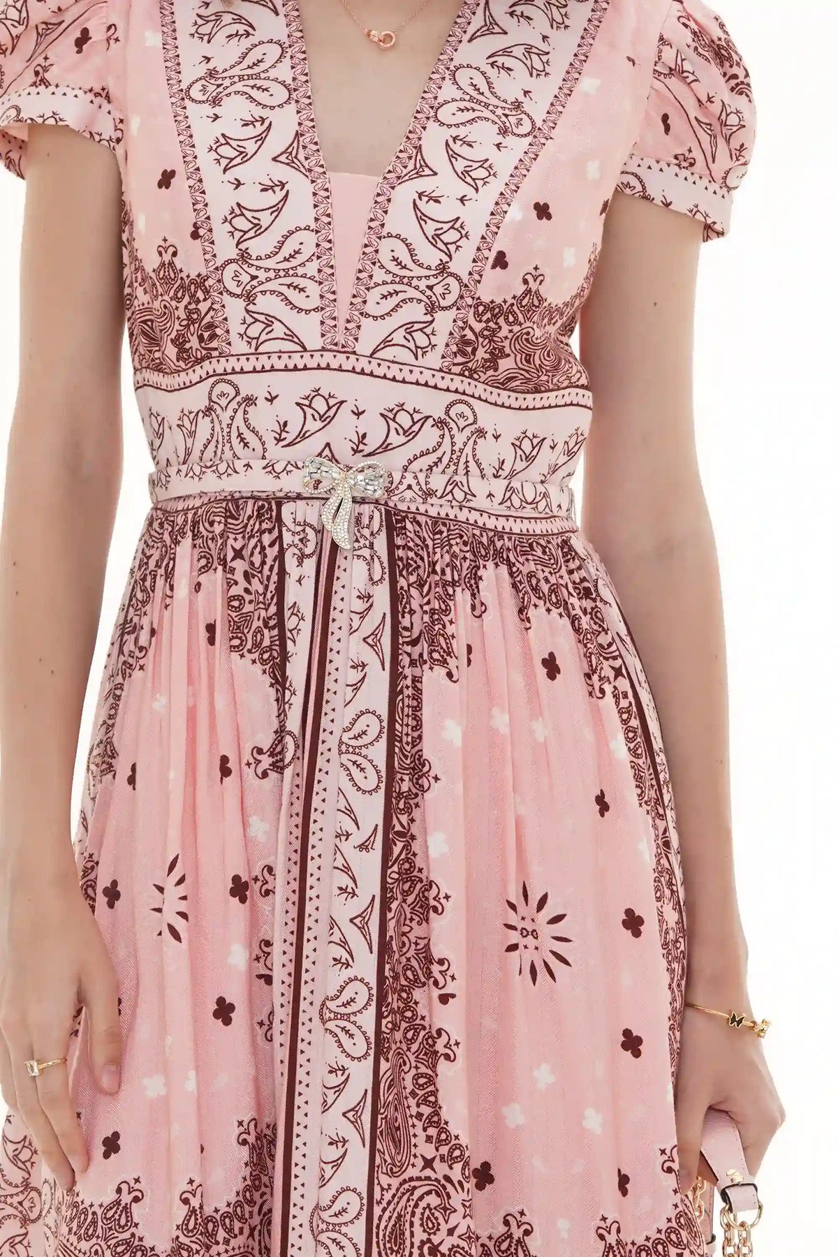 Close-up of Pretty Pixie pink bandana-print V-neck belted dress with crystal bow brooch