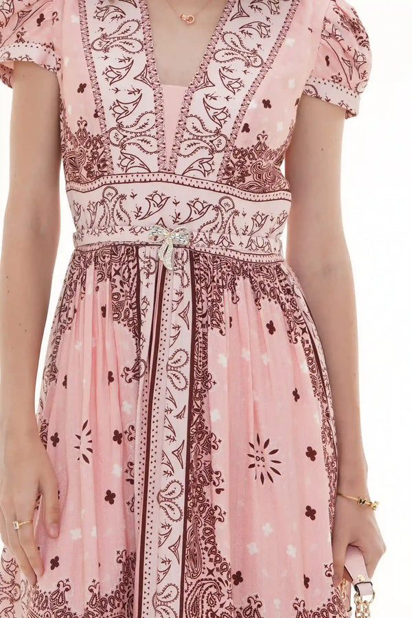 Close-up of Pretty Pixie pink bandana-print V-neck belted dress with crystal bow brooch