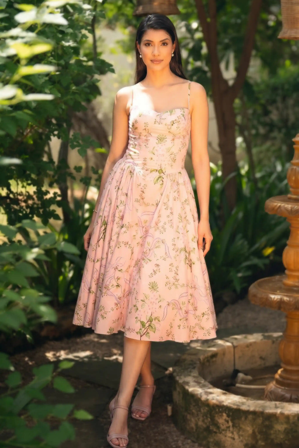 Woman in pink floral cotton midi dress with structured bustier bodice thin straps botanical
