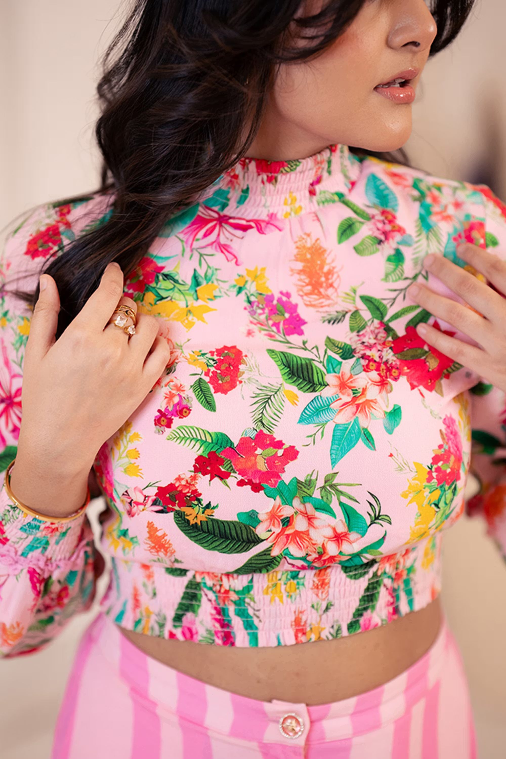 Close-up of floral crop top with striped pink pants, front view