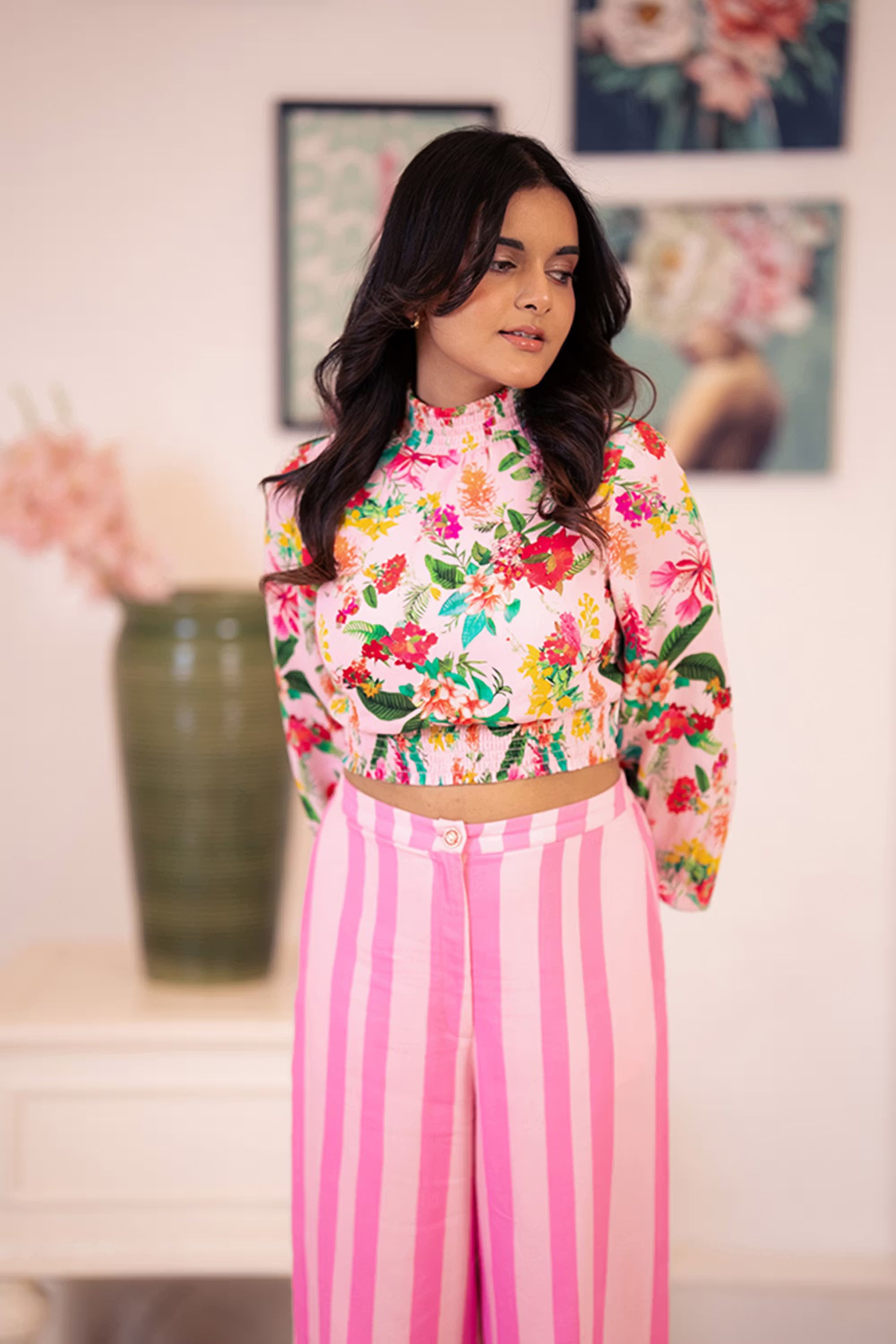 Model in pink floral crop top with striped pants, front view