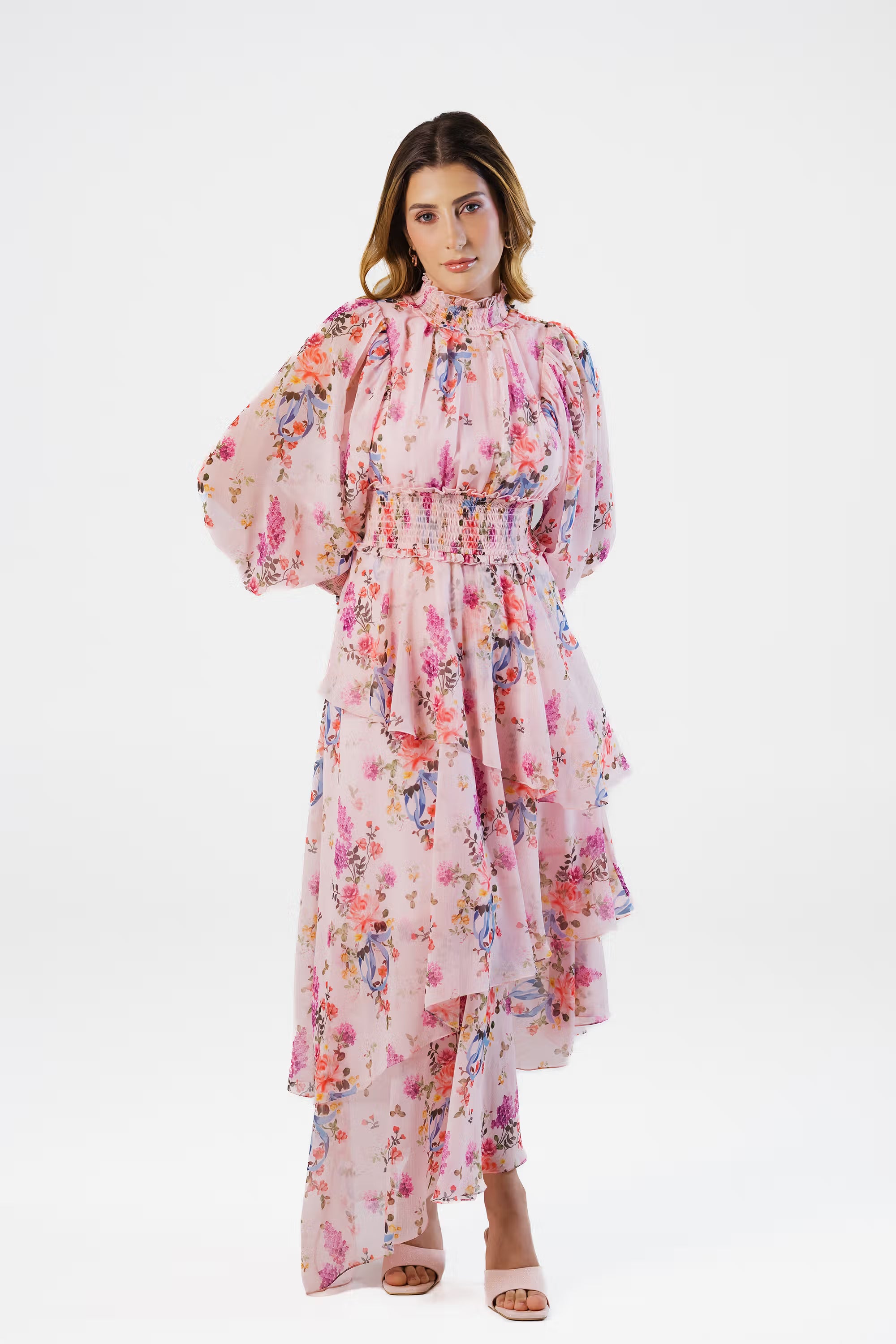 Woman in pink floral high neck layered maxi dress with long sleeves, front view
