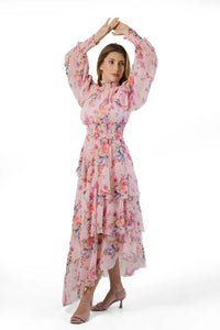 Arms-up pose in pink floral high-neck tiered maxi showing flowy sleeves