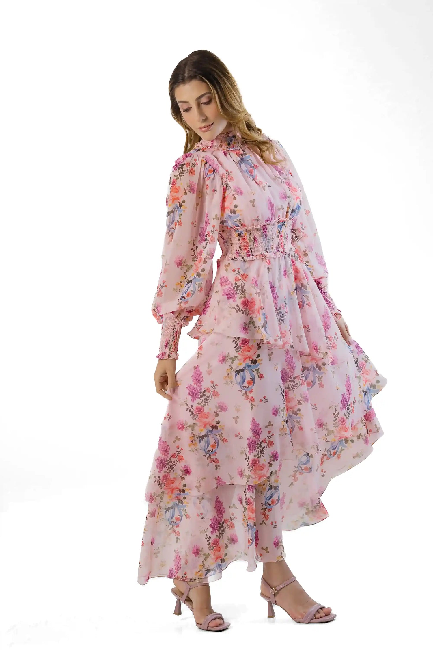 Three-quarter view: pink floral high-neck maxi, smocked waist, layered skirt