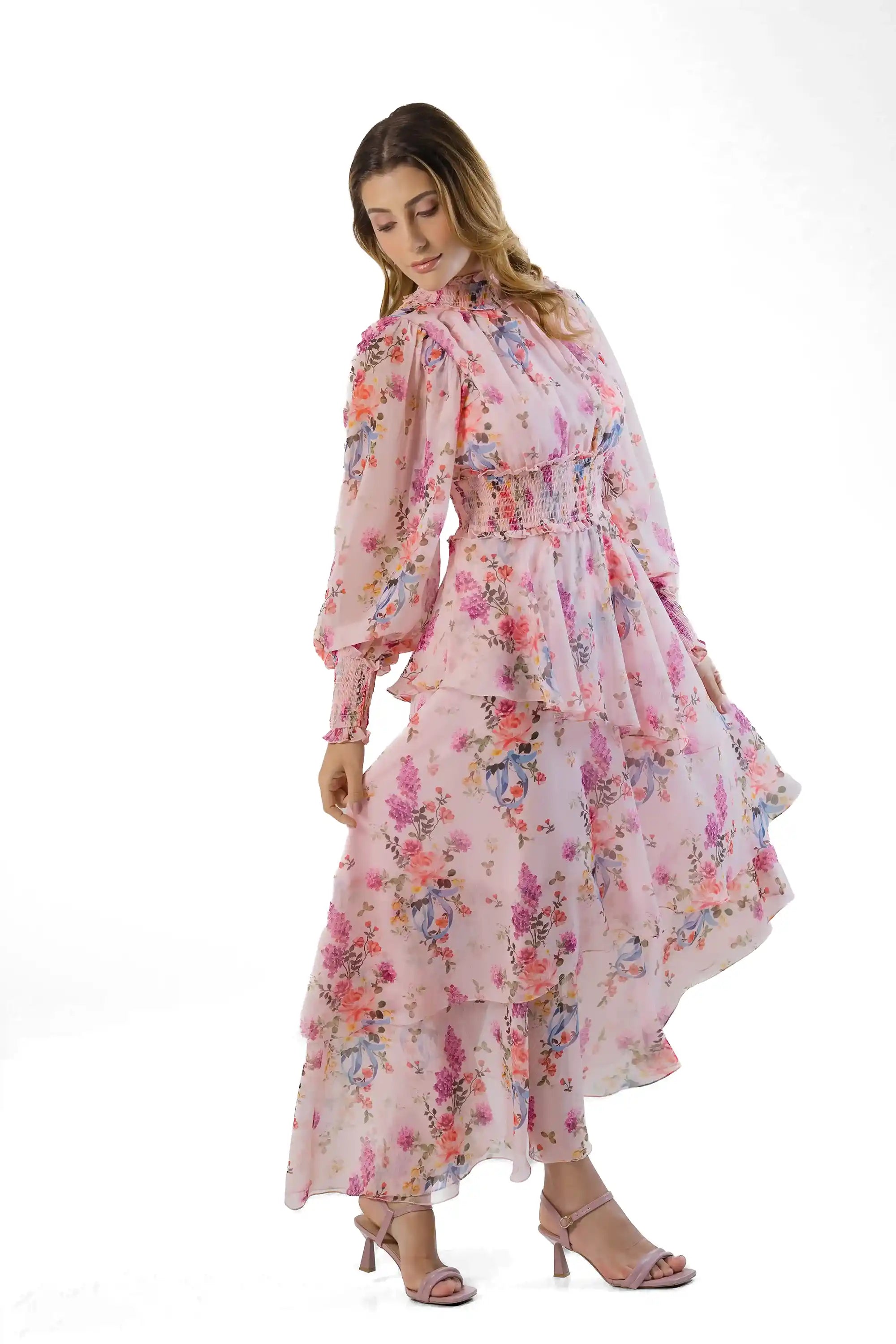 Three-quarter view: pink floral high-neck maxi, smocked waist, layered skirt