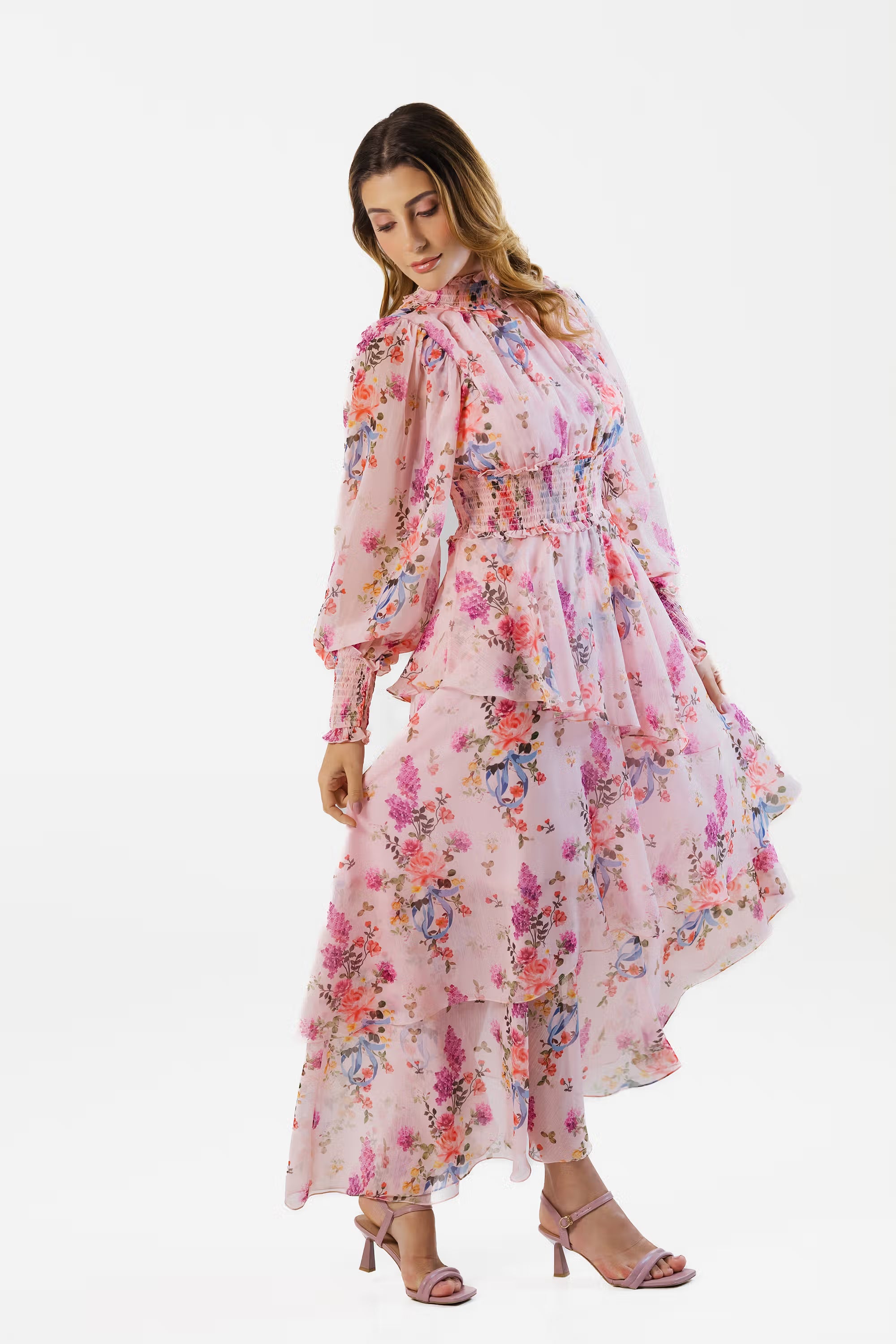 Woman turning in pink floral maxi dress with layered hem and puff sleeves
