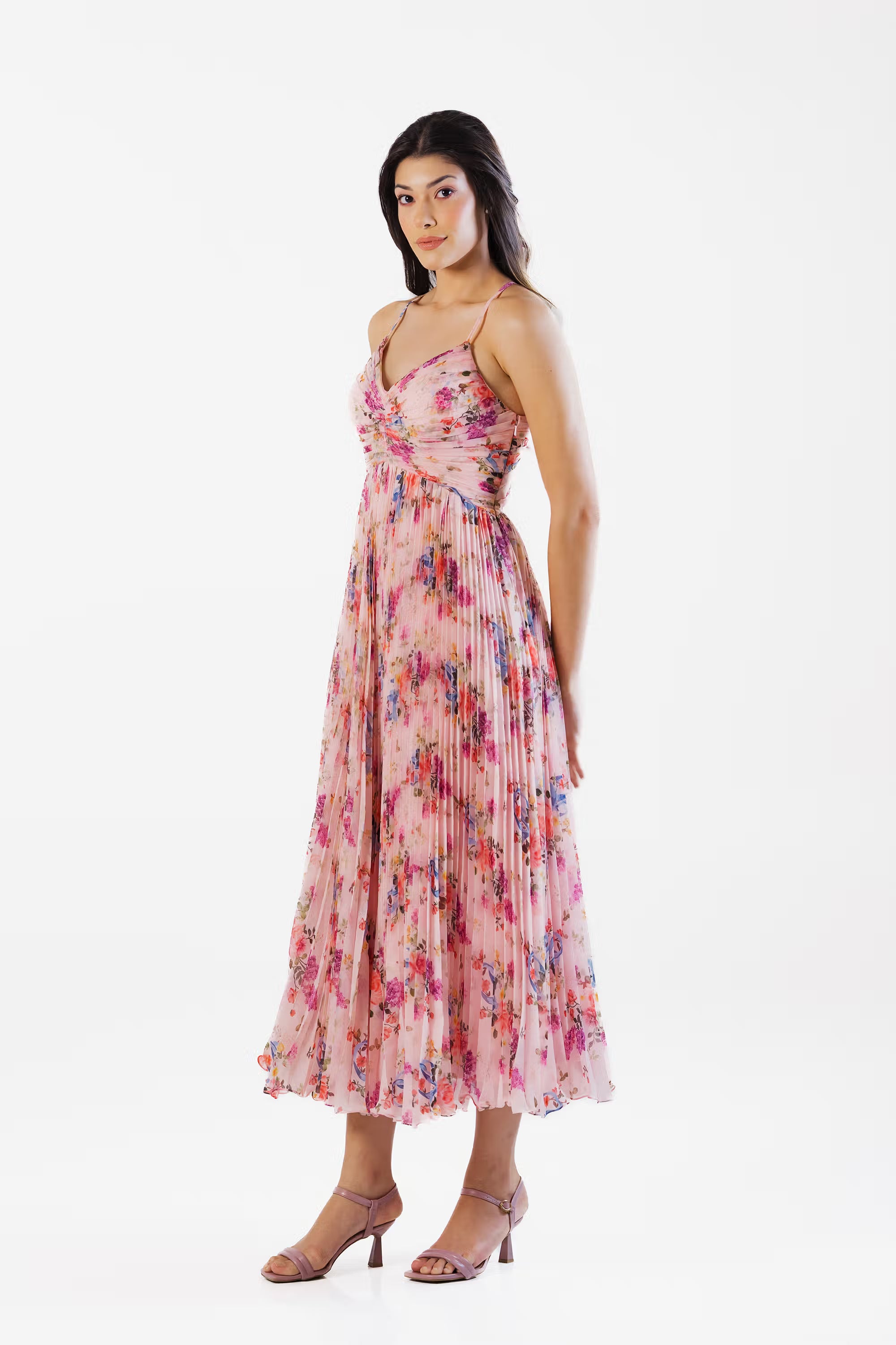 Side profile of pink floral pleated maxi dress with spaghetti straps and empire waistline.