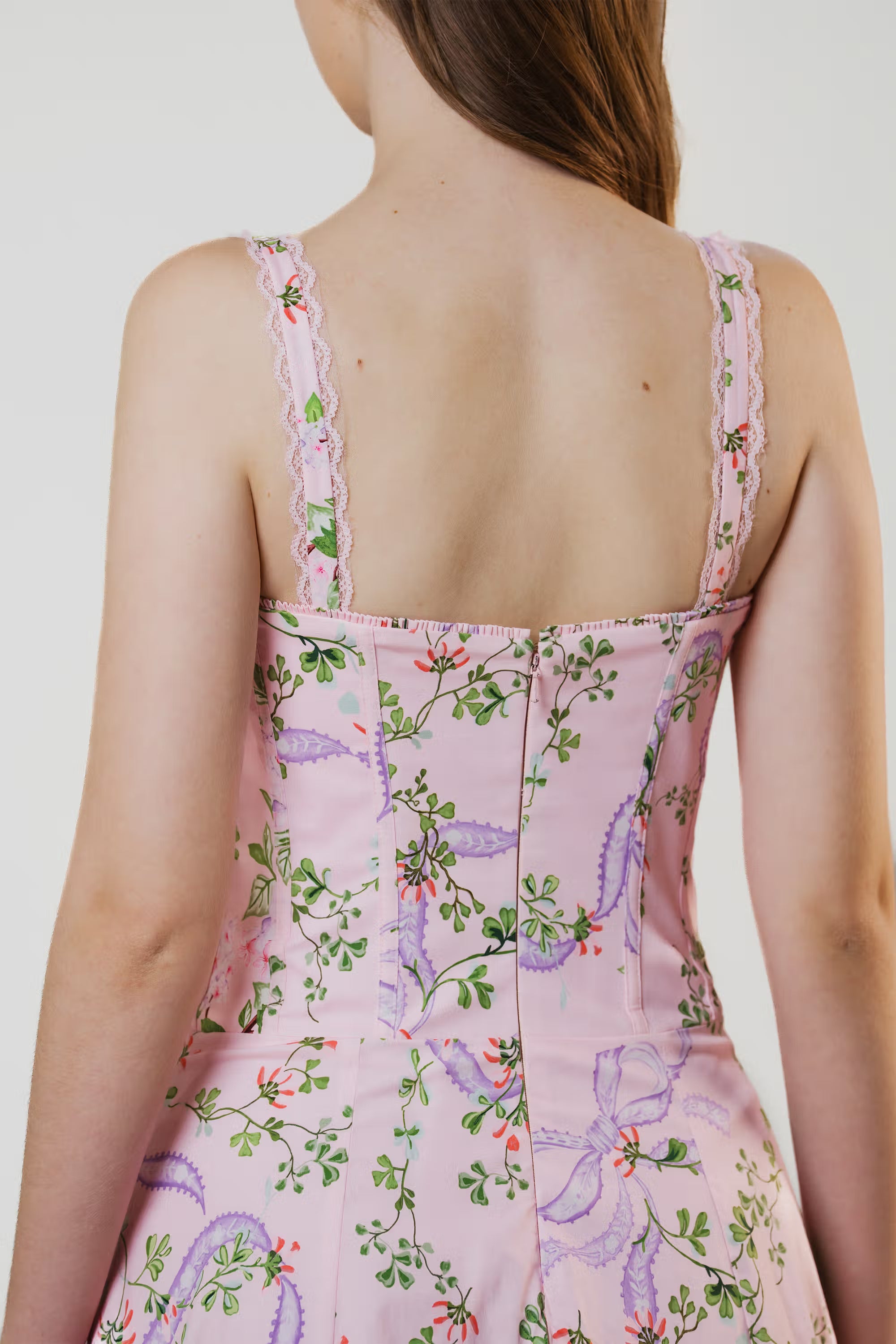 Close-up of pink floral corset dress back zipper and lace strap details