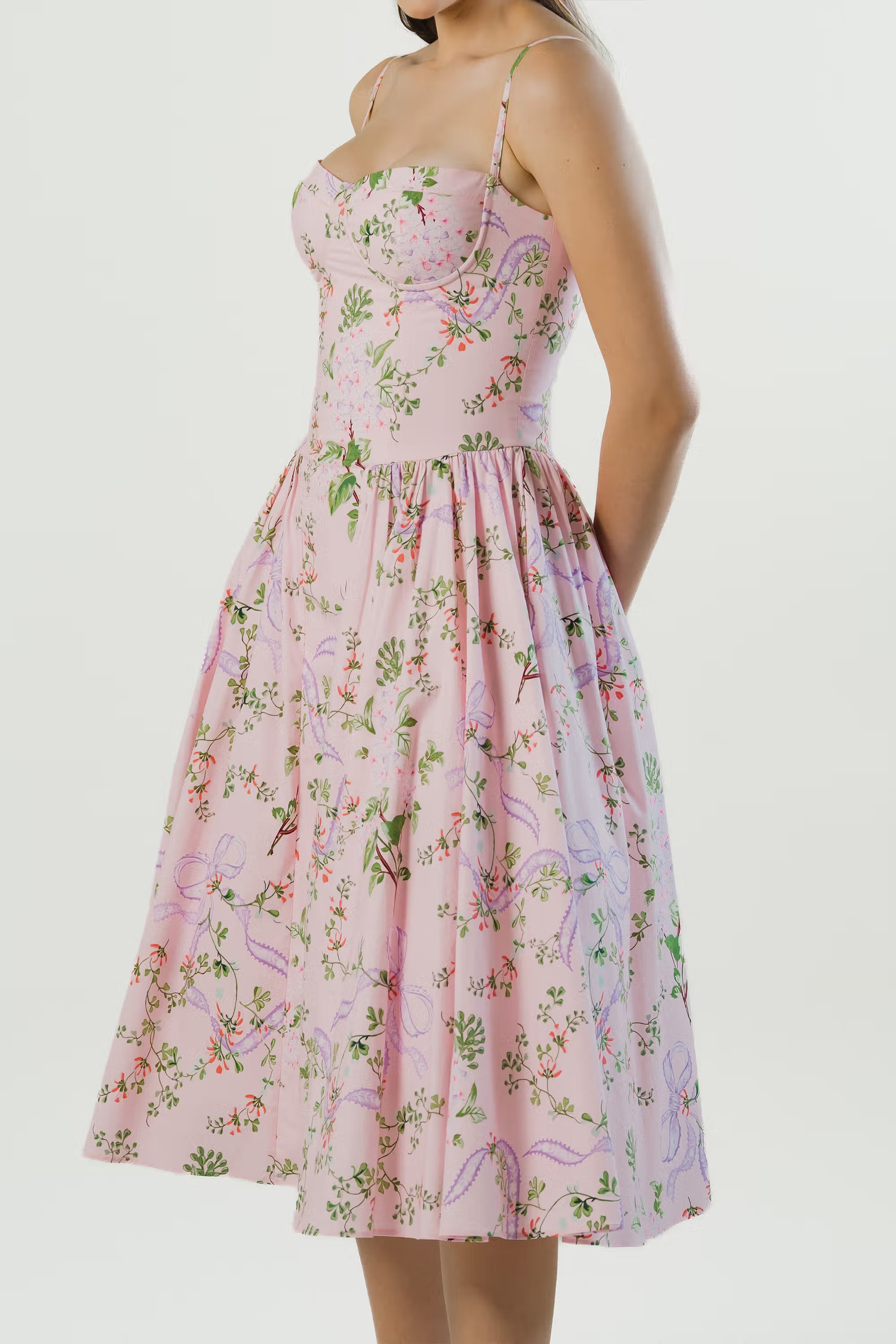 Side view of pink floral midi dress featuring practical hidden pockets and a flowy skirt.