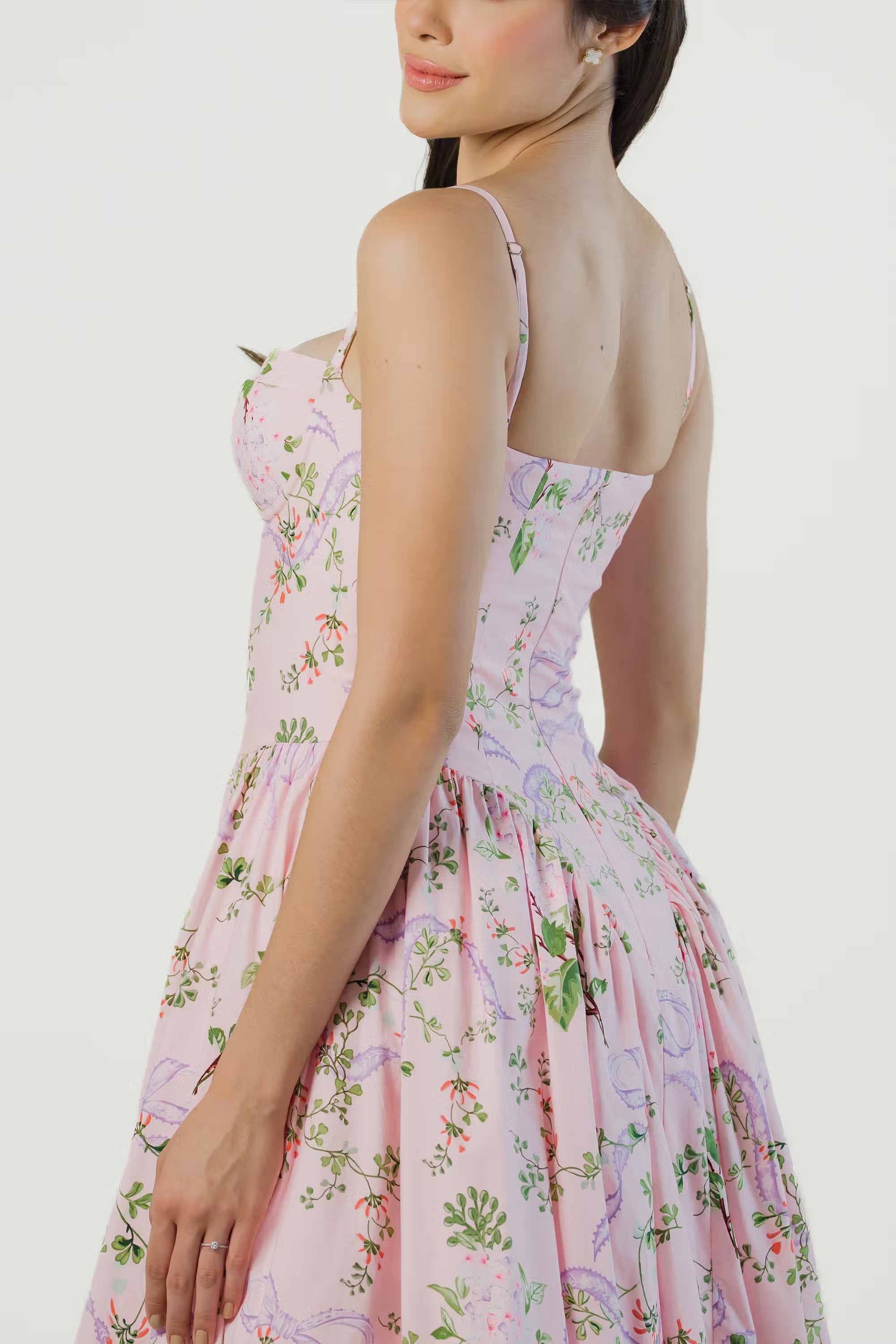 Side view of pink floral midi dress with fitted corset bodice, pleated skirt, and delicate floral print – chic summer outfit for women