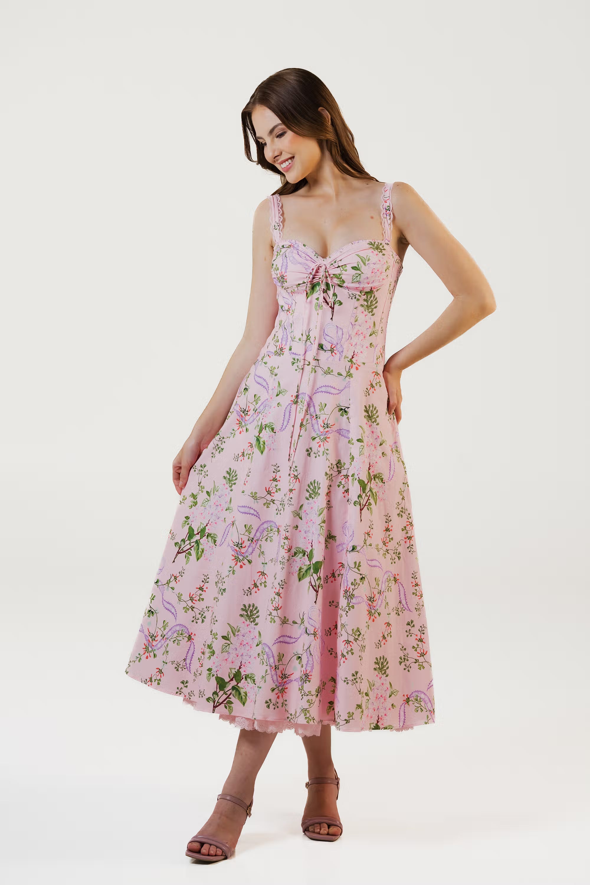 Pink floral midi dress with corset bodice and lace straps, side pose with smile